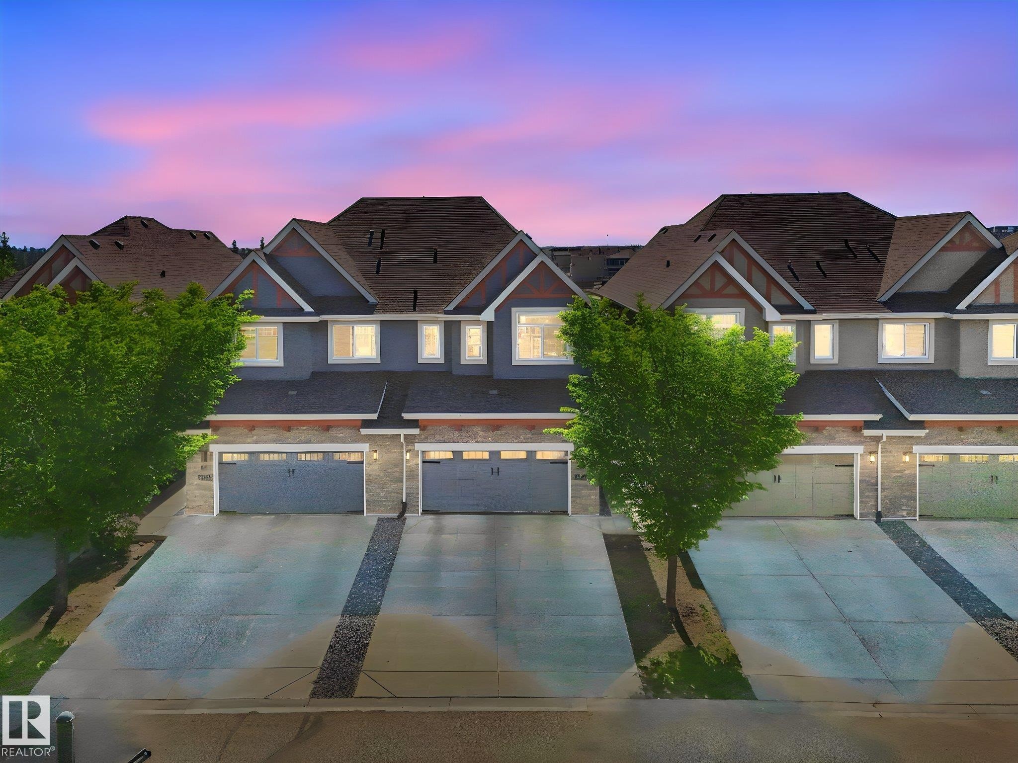 Modern townhomes featuring multi-tone siding, stone accents, and pitched roofs - 3 1641 James Mowatt Trail, Edmonton, AB
