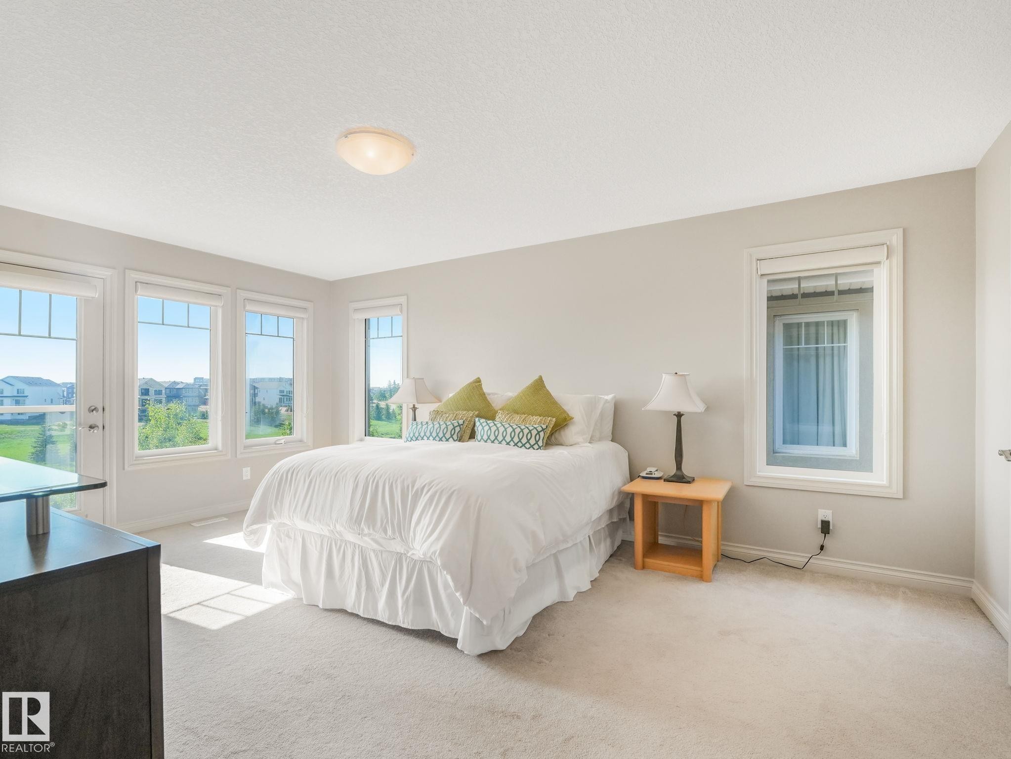 Carpeted room featuring multiple windows offering abundant natural light - 3 1641 James Mowatt Trail, Edmonton, AB