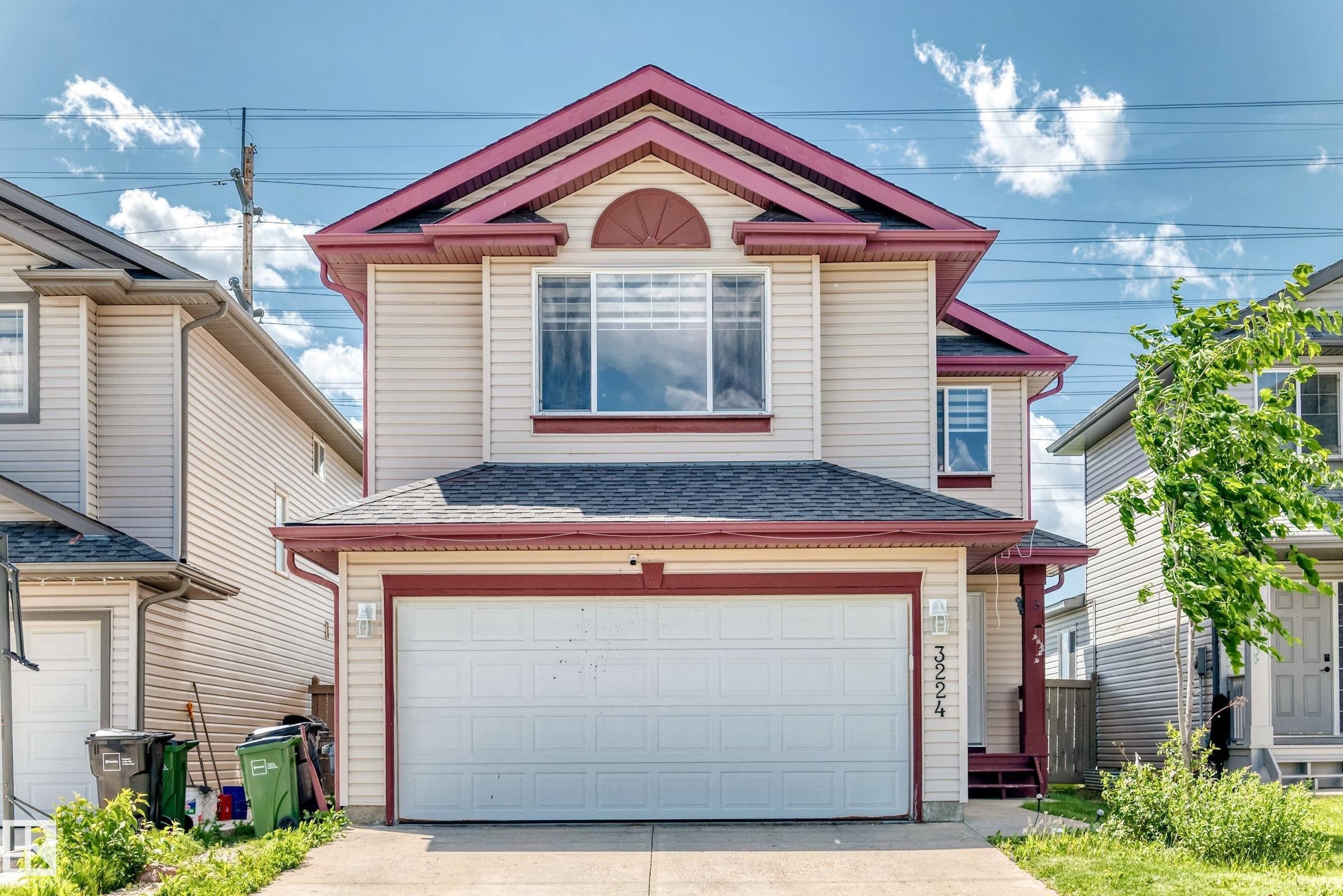 Two-story residence featuring light-colored siding with red trim accents - 3224 26 Street, Edmonton, AB