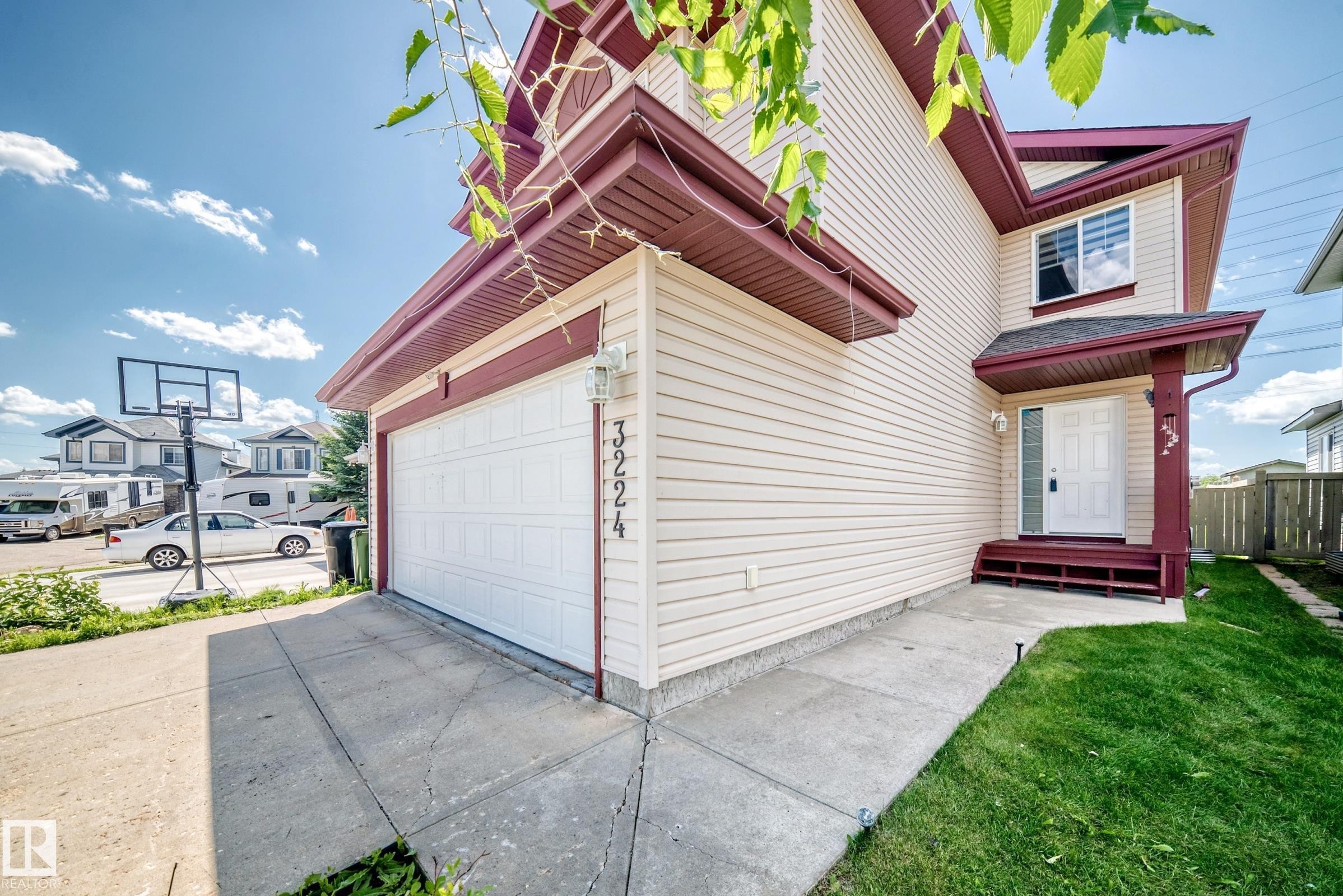 Cream-colored siding facade with contrasting burgundy trim - 3224 26 Street, Edmonton, AB