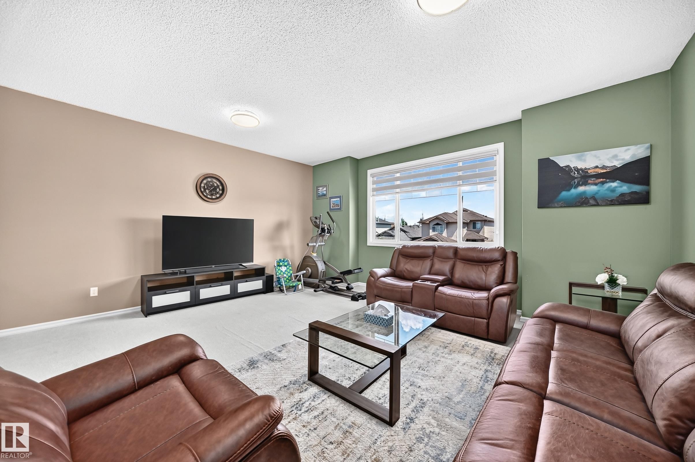 Spacious living area featuring light-toned walls and a contrasting accent wall - 3224 26 Street, Edmonton, AB