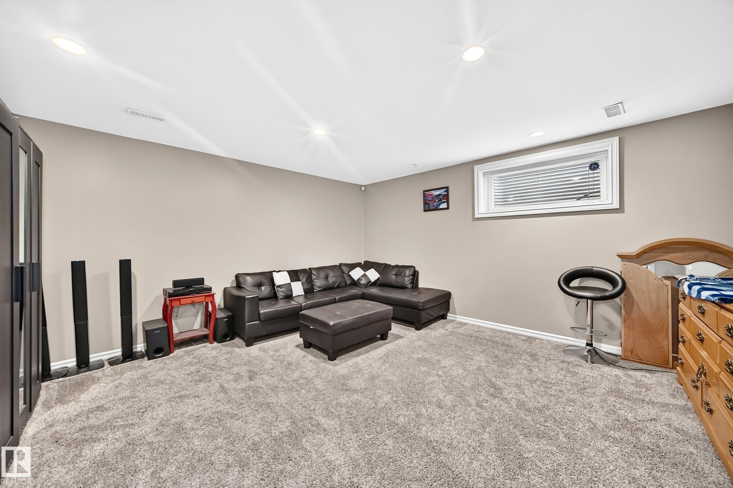 Spacious room featuring neutral painted walls, recessed lighting, and grey carpeting - 3224 26 Street, Edmonton, AB