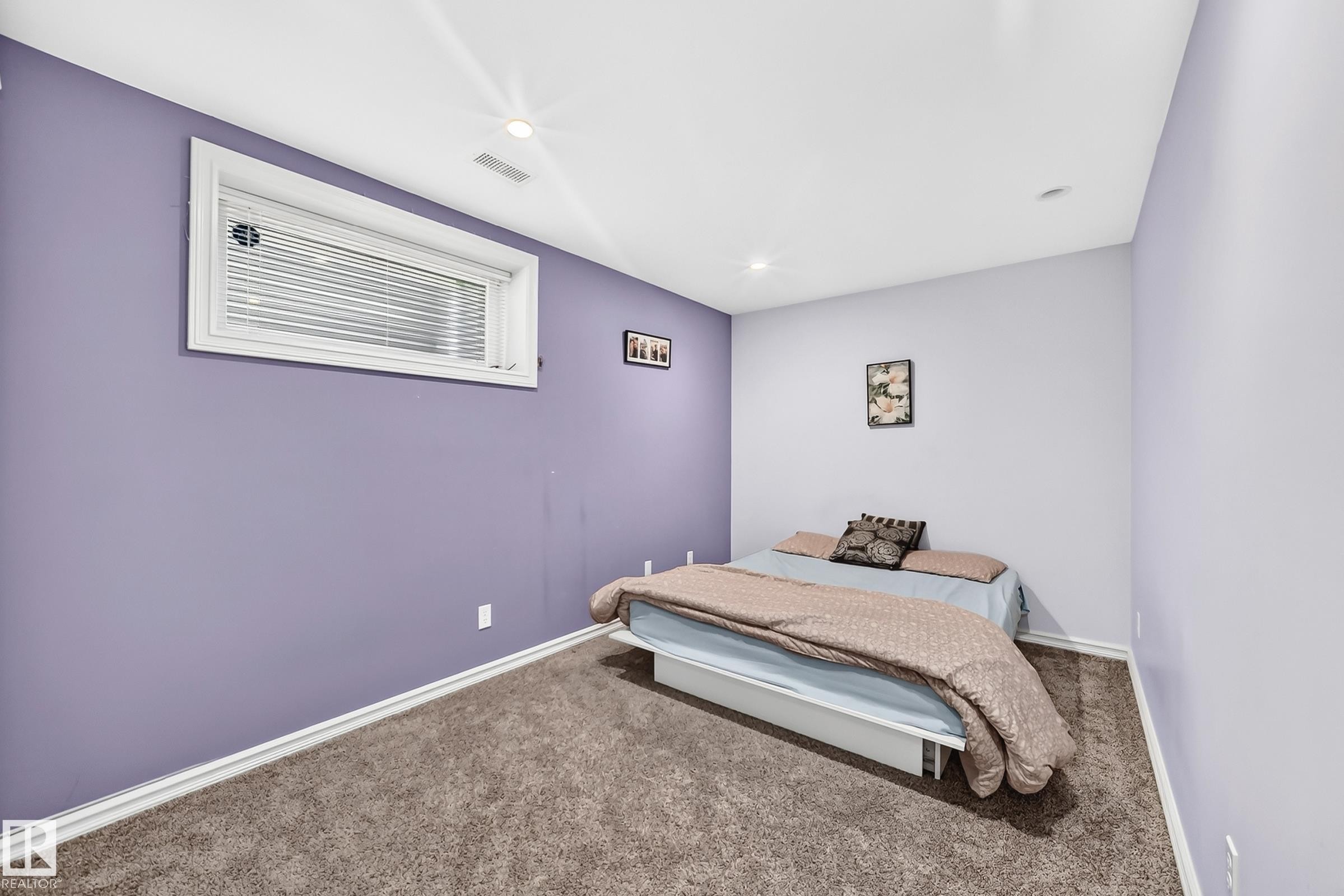 Carpeted room featuring a white-framed window with blinds, recessed lighting, and light purple painted walls - 3224 26 Street, Edmonton, AB