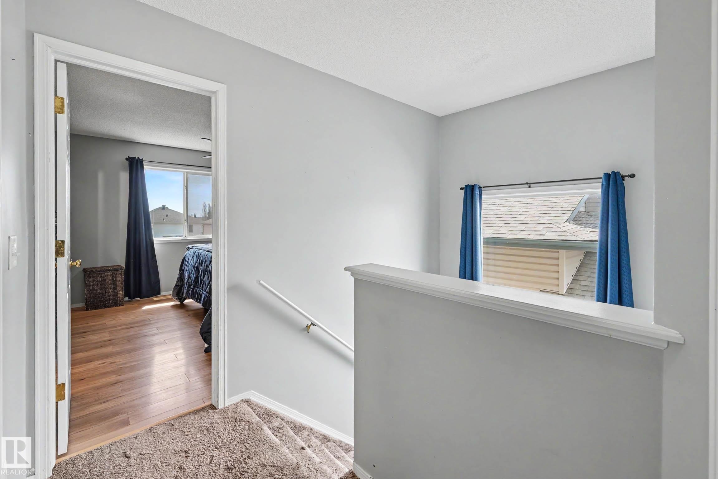 Upper-level landing featuring a carpeted staircase and a window with a sill - 2123 36 Avenue, Edmonton, AB - Indoor Photo Showing Other Room