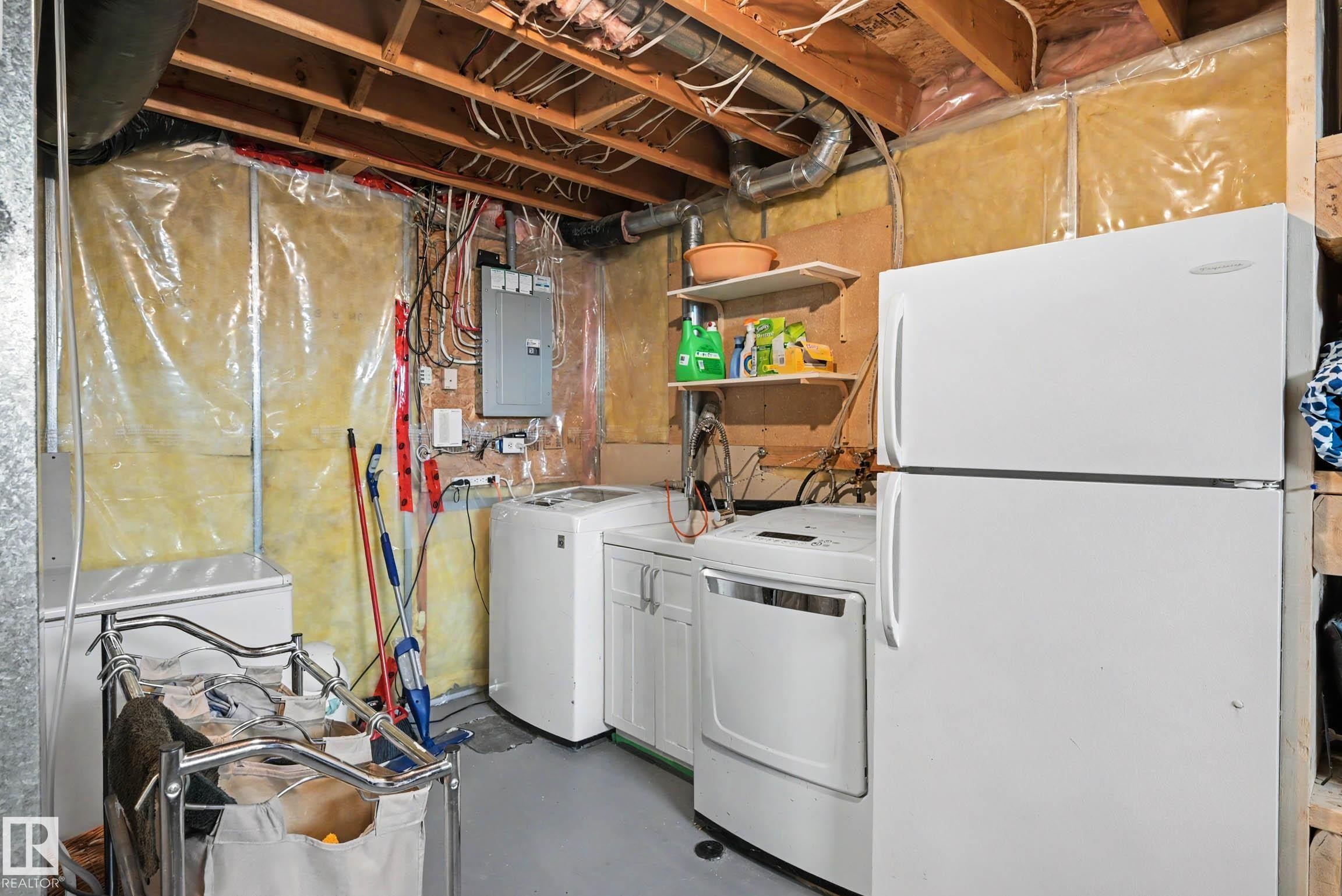 Utility space featuring exposed ceiling joists, insulated walls, and a laundry setup with a washer and dryer - 2123 36 Avenue, Edmonton, AB - Indoor