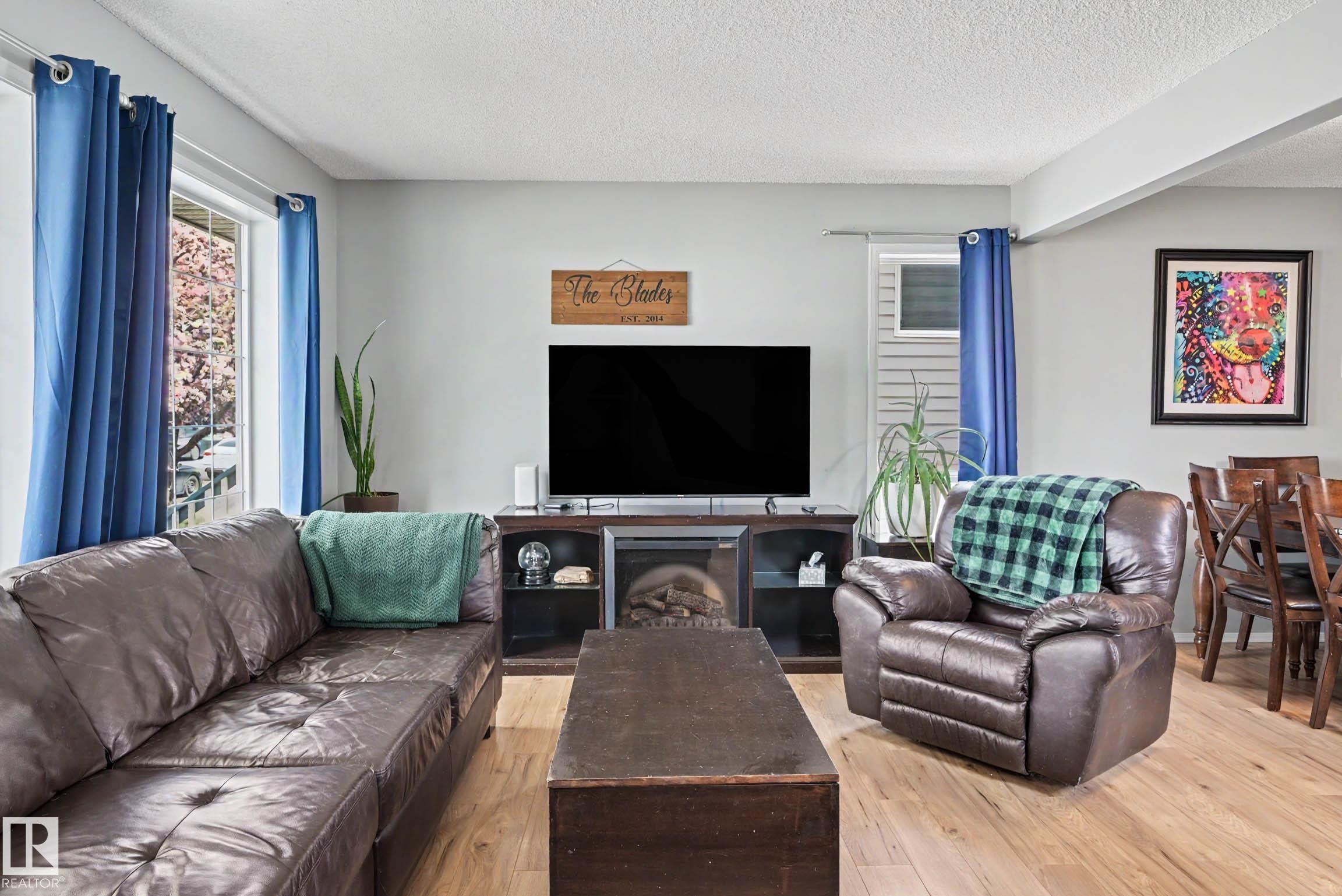 Light-toned wood-finish flooring extends throughout this open-concept living space - 2123 36 Avenue, Edmonton, AB - Indoor Photo Showing Living Room