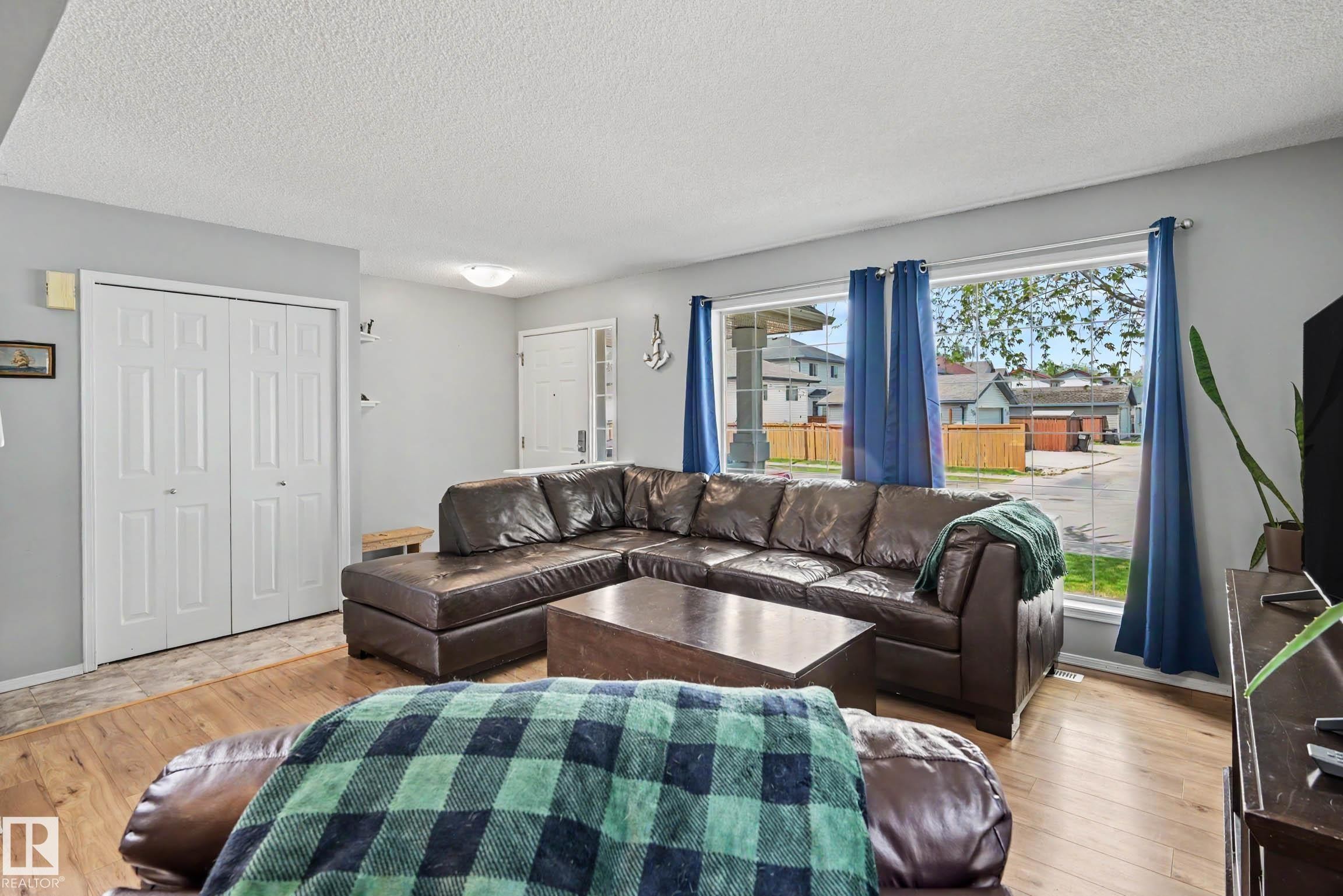 Living area featuring wood-finish flooring, light grey painted walls, and white trim - 2123 36 Avenue, Edmonton, AB - Indoor Photo Showing Living Room