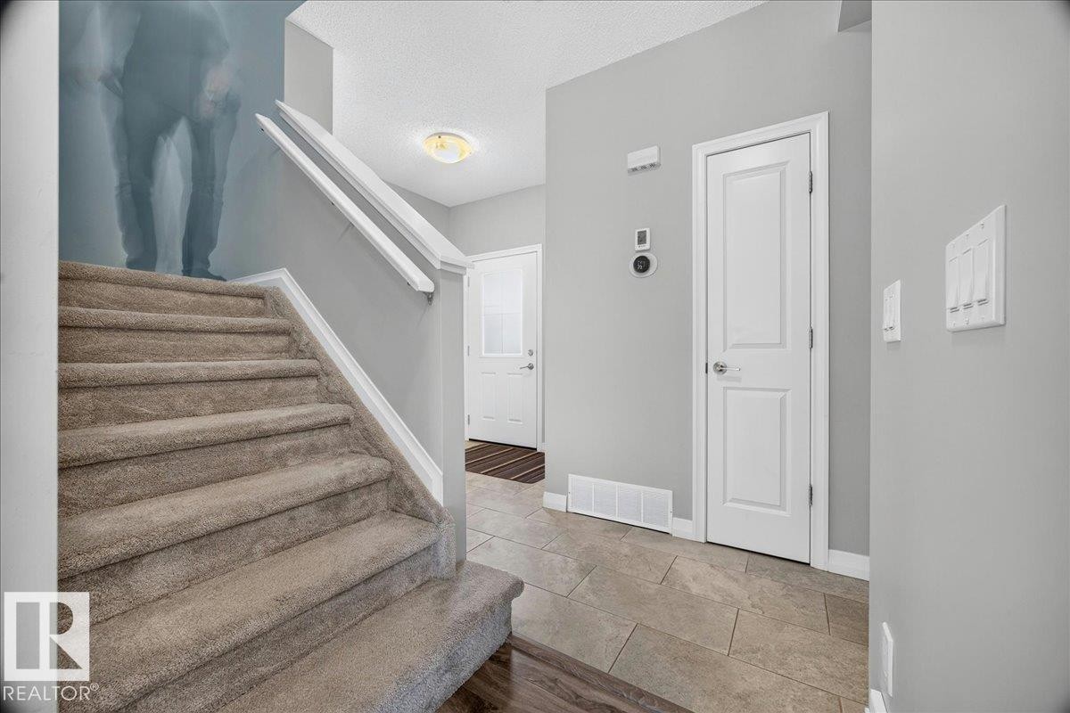 Carpeted staircase with white handrails - 17203 71 Street, Edmonton, AB