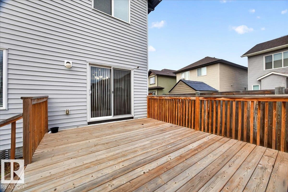 Spacious wooden deck featuring a perimeter railing and direct access via a sliding glass door - 17203 71 Street, Edmonton, AB