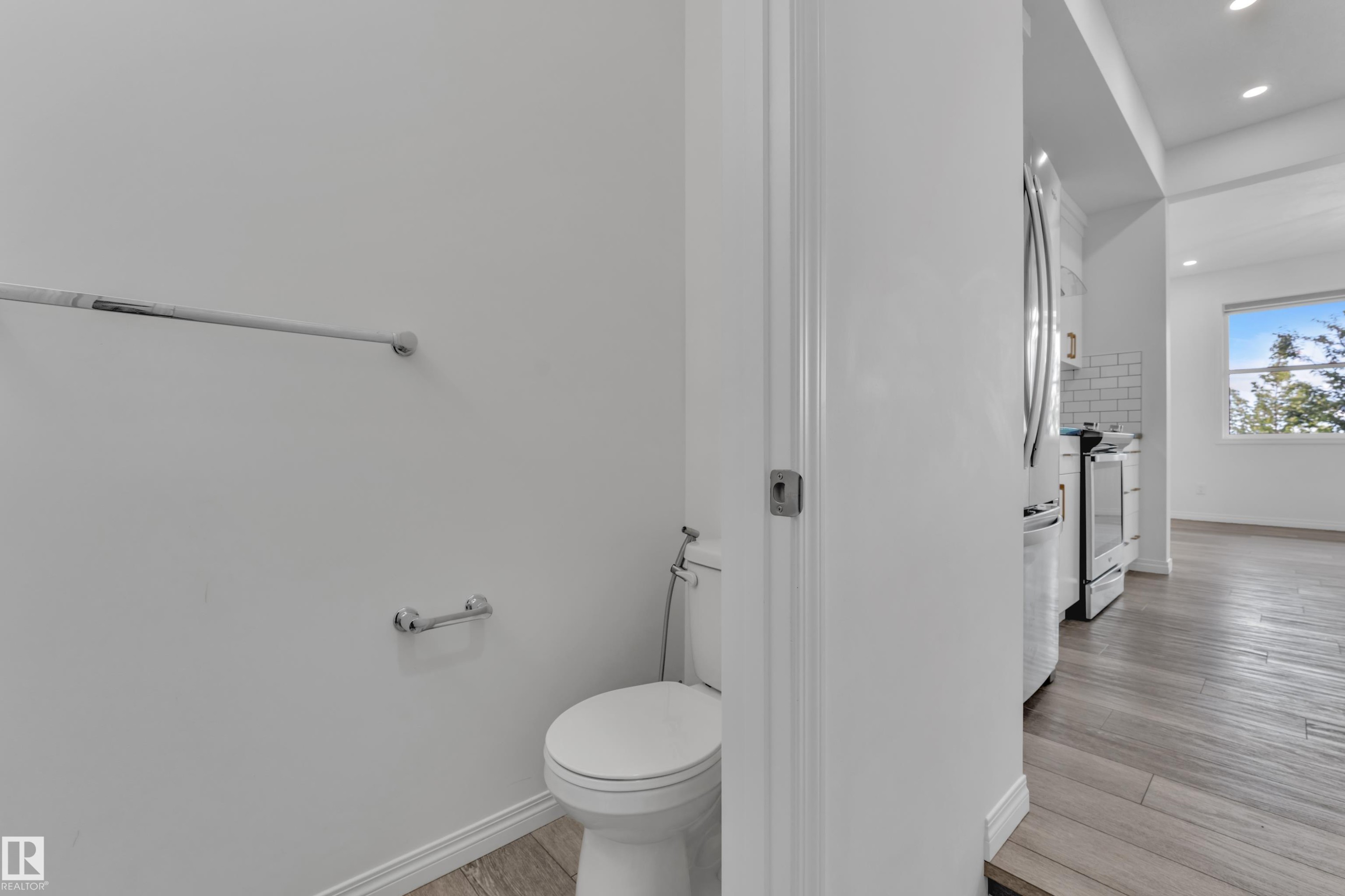 Compact powder room featuring a white toilet and chrome fixtures - 144 Sunwapta Way, Edmonton, AB
