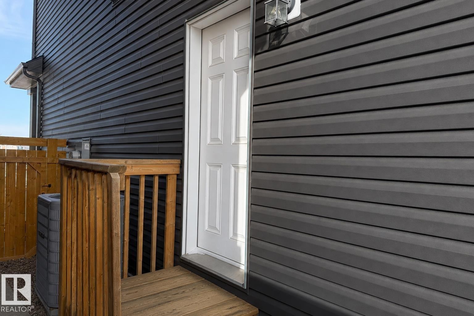Dark gray horizontal siding exterior with a white paneled door - 1199 Watt Drive, Edmonton, AB