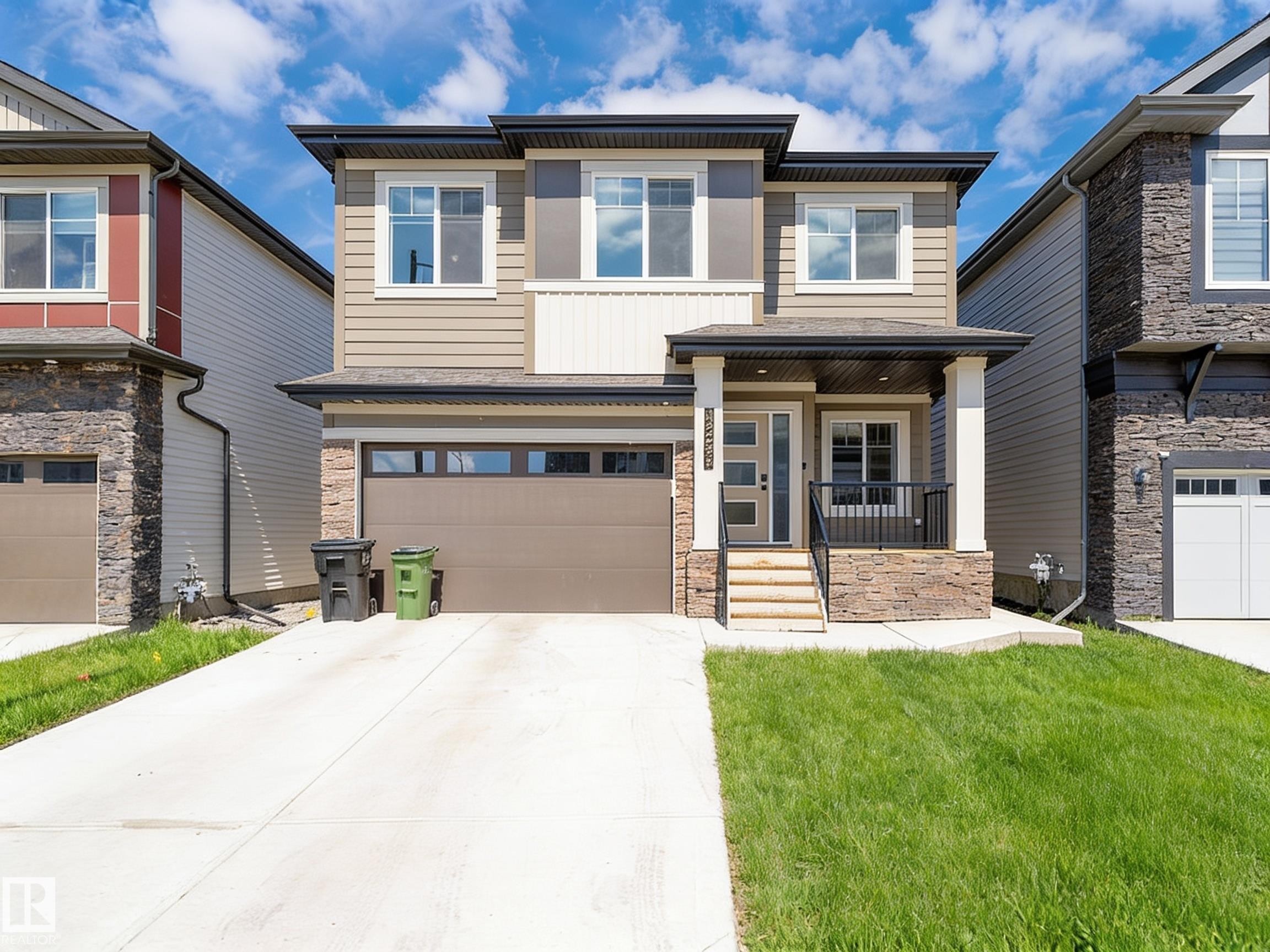 Contemporary two-story residence featuring a covered entry porch, stone accents, and varied siding textures - 17320 9 Avenue, Edmonton, AB