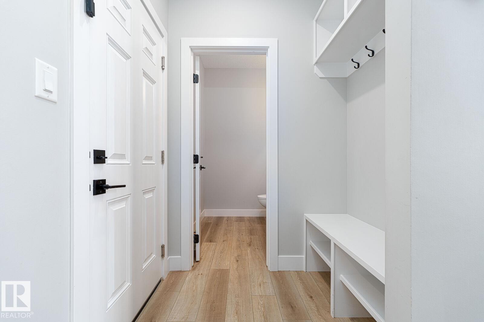 Integrated built-in bench seating with storage, overhead shelving, and coat hooks - 17320 9 Avenue, Edmonton, AB