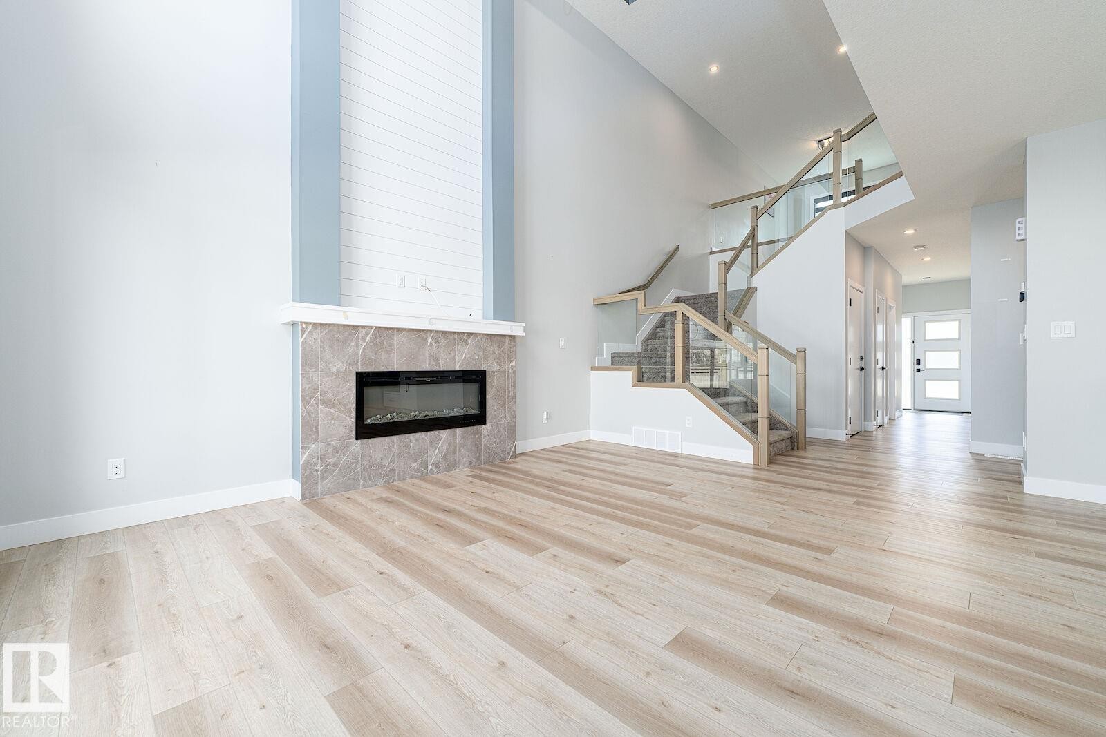 Spacious interior with vaulted ceilings, featuring light wood-finish flooring throughout - 17320 9 Avenue, Edmonton, AB