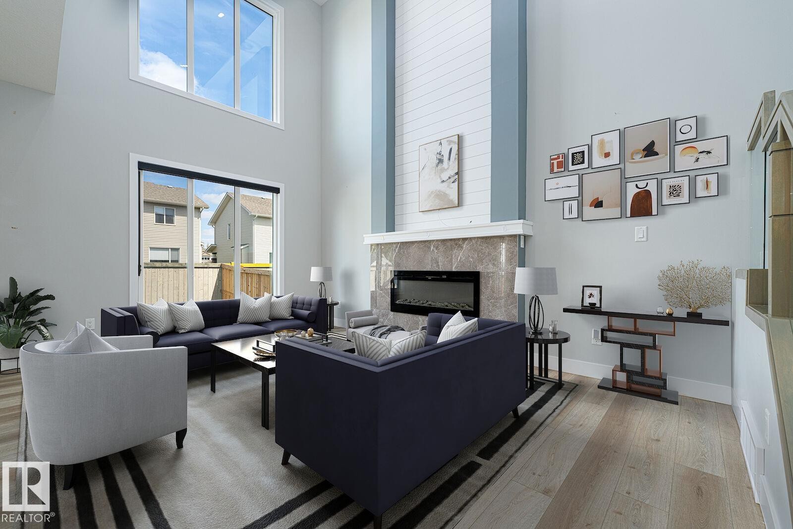 Expansive living area with soaring ceilings and abundant natural light from large windows and an upper transom - 17320 9 Avenue, Edmonton, AB