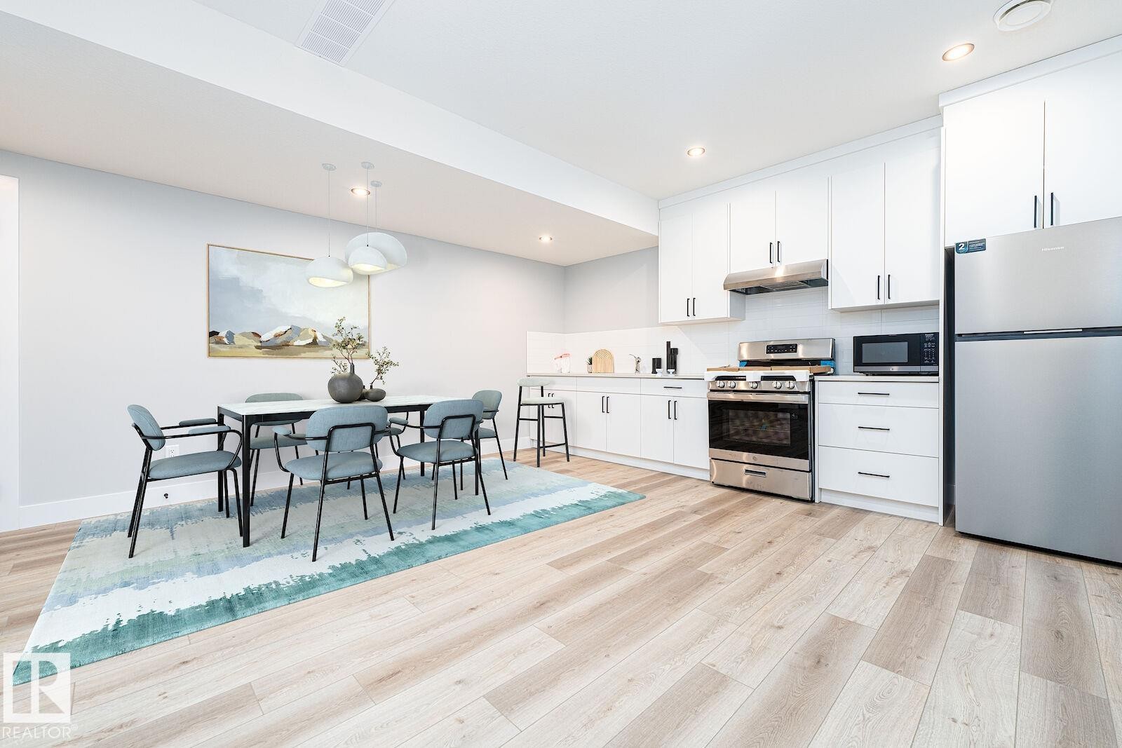 Open-concept kitchen and dining area featuring light wood-finish flooring - 17320 9 Avenue, Edmonton, AB