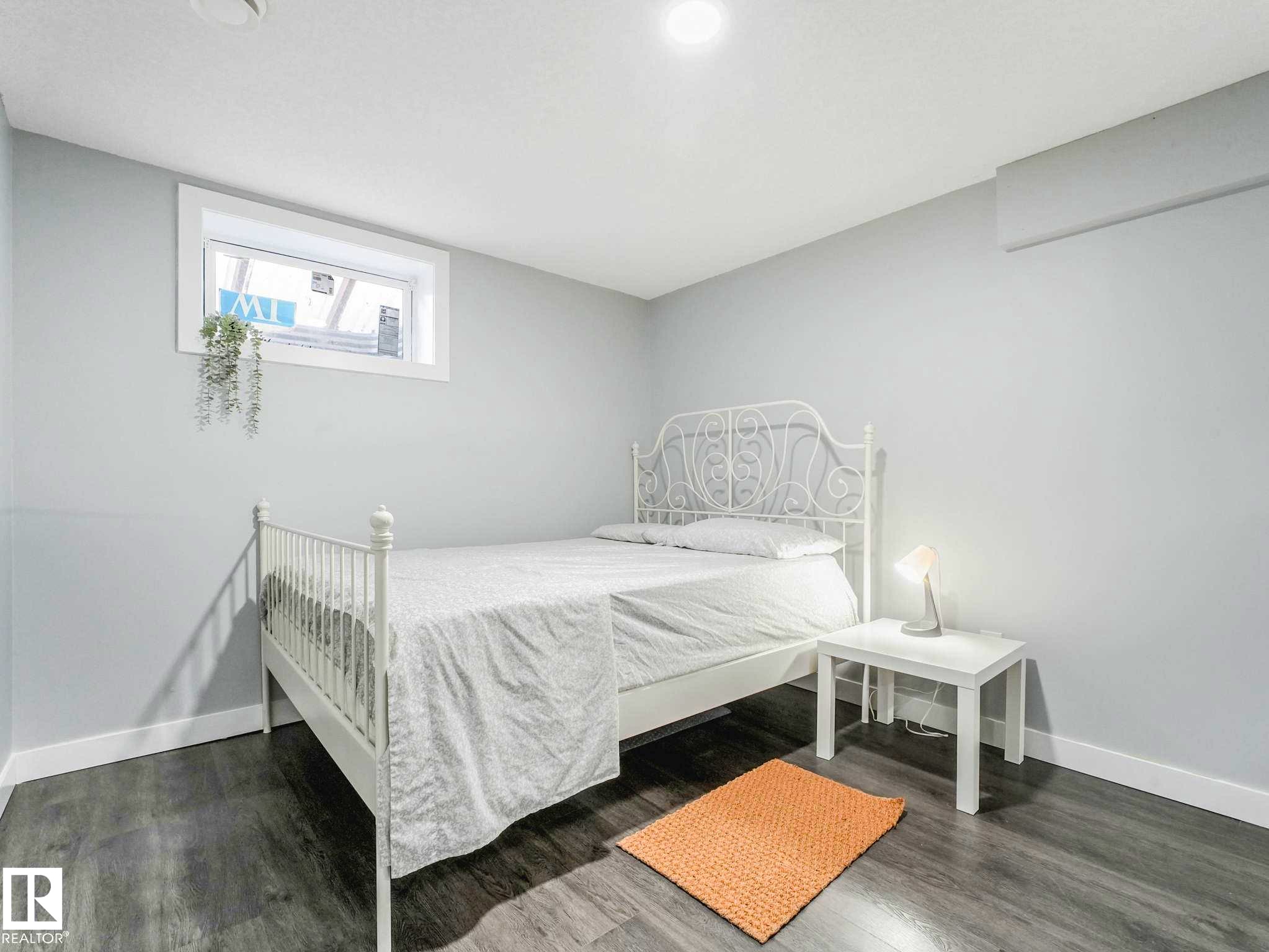 Light grey walls complement wood-finish flooring - 9207 169 Street, Edmonton, AB - Indoor Photo Showing Bedroom