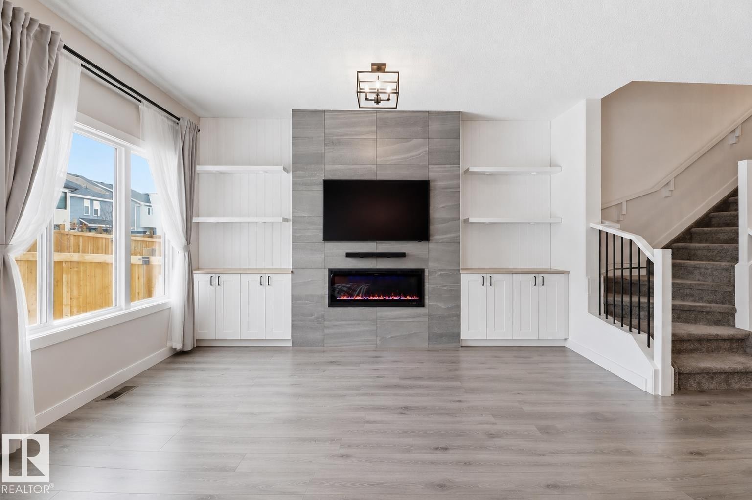 Living area featuring light wood-finish flooring and a large window - 3234 Chernowski Way, Edmonton, AB