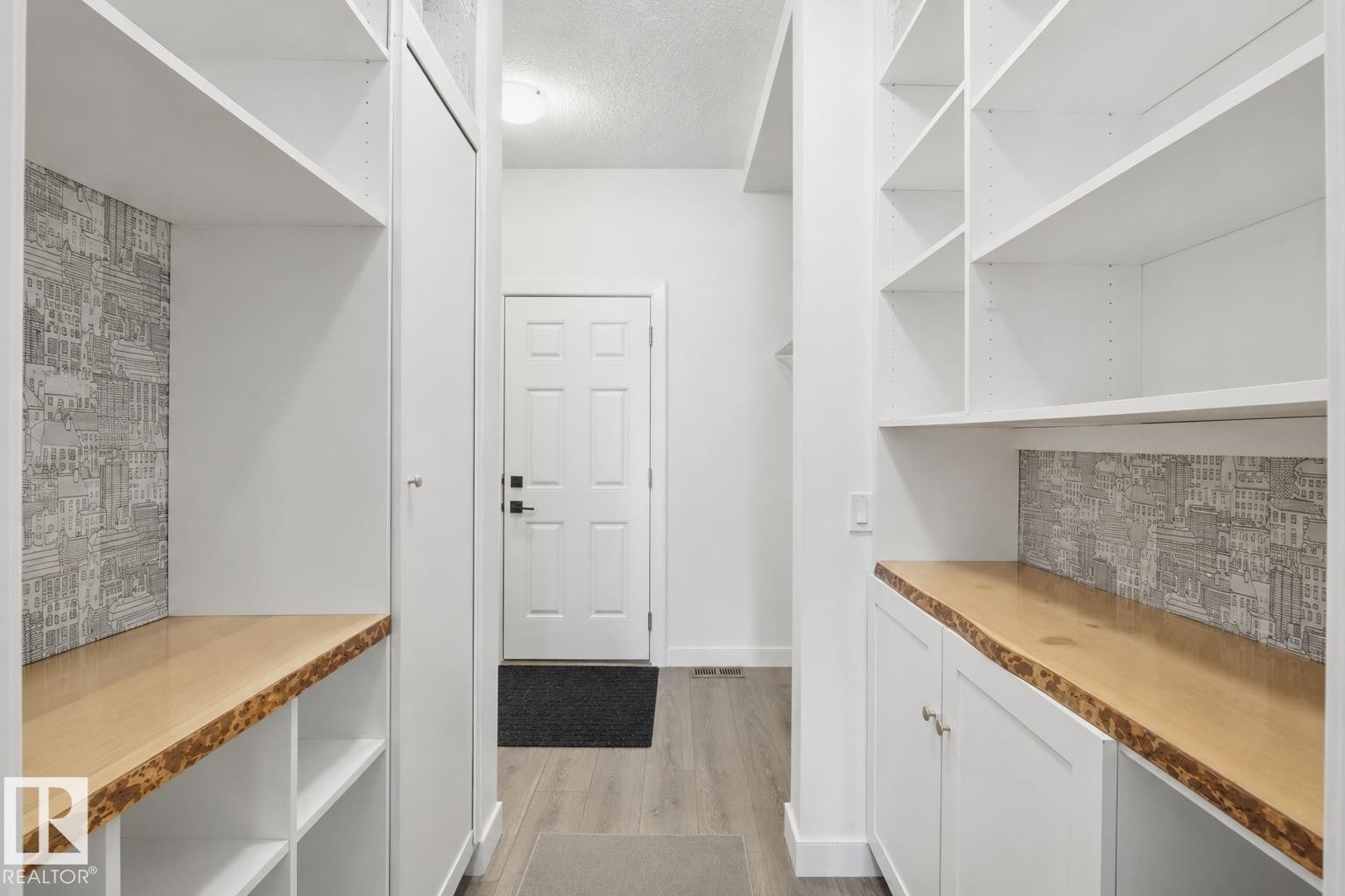 Entryway featuring white built-in cabinetry and shelving, live-edge wood countertops, and decorative wall paneling - 3234 Chernowski Way, Edmonton, AB