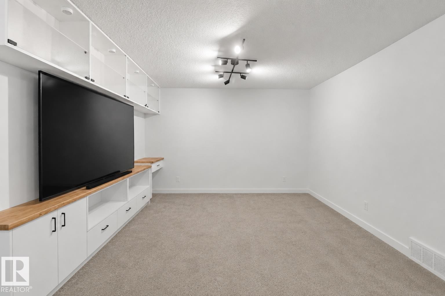 Integrated white cabinetry with wood-finish countertops and shelving - 3234 Chernowski Way, Edmonton, AB