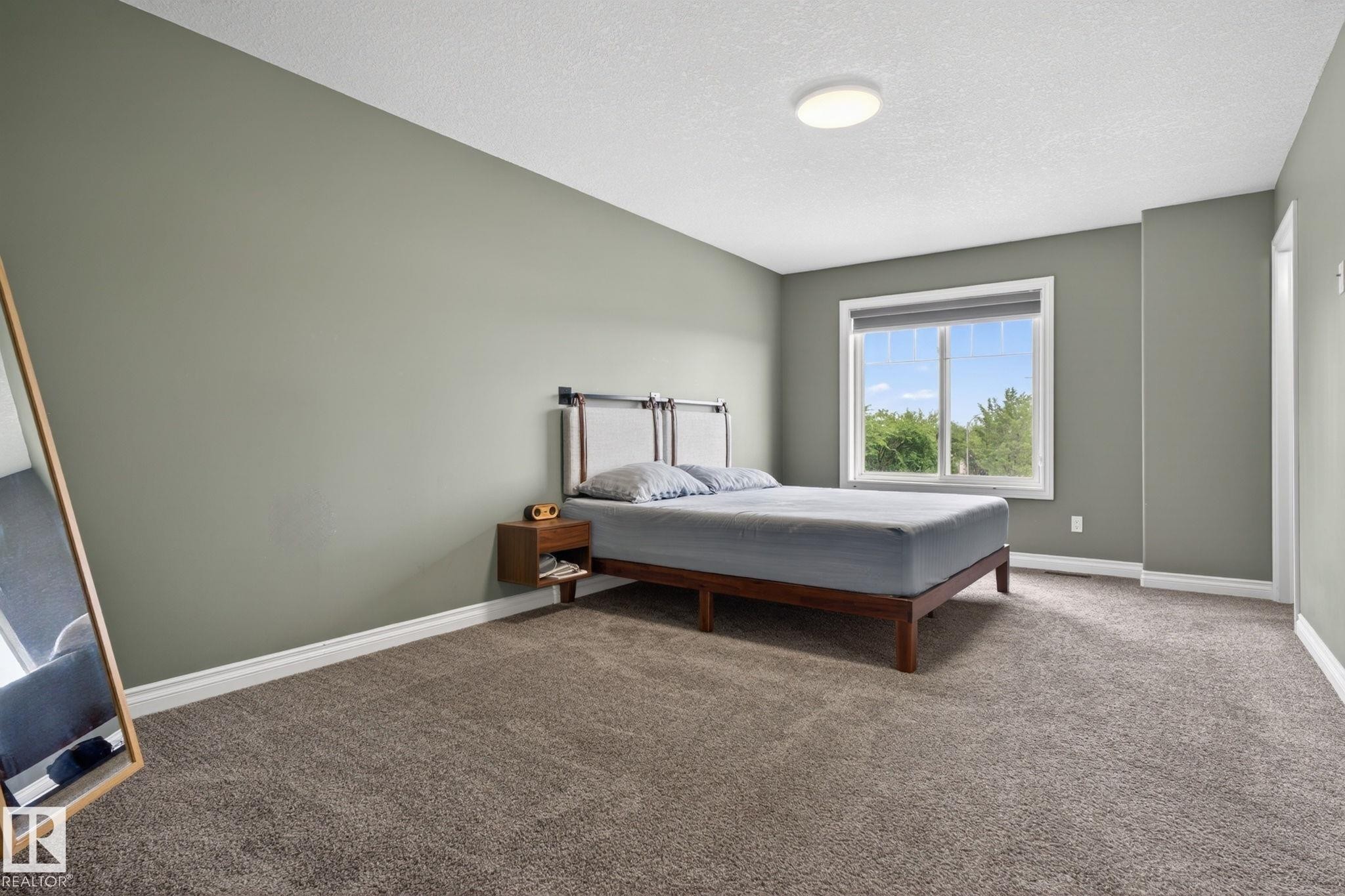 Bedroom featuring plush gray carpeting, neutral green walls, and white trim - 9628 221 Street, Edmonton, AB