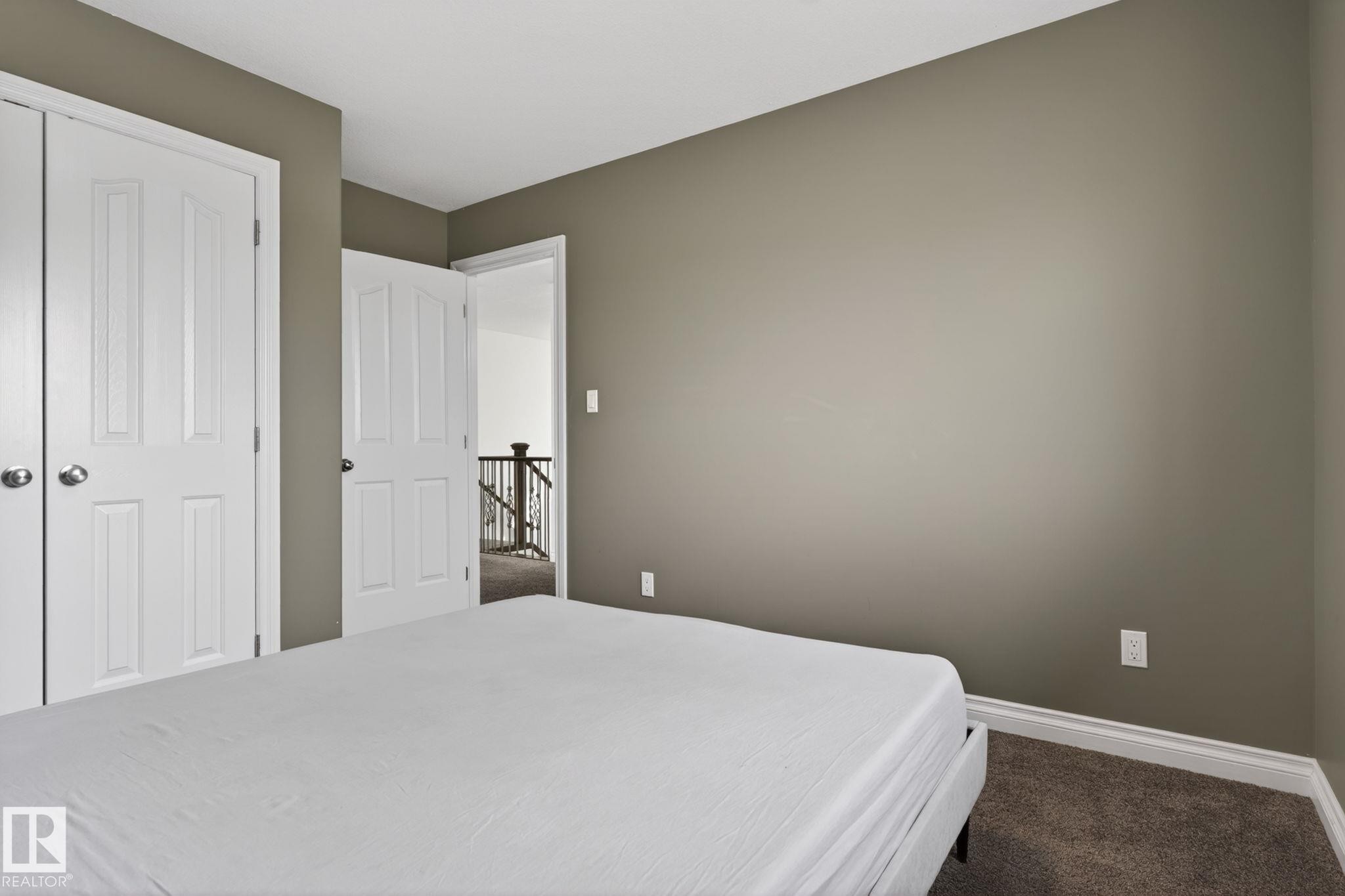 Bedroom featuring neutral wall paint, white trim, and a carpeted floor - 9628 221 Street, Edmonton, AB