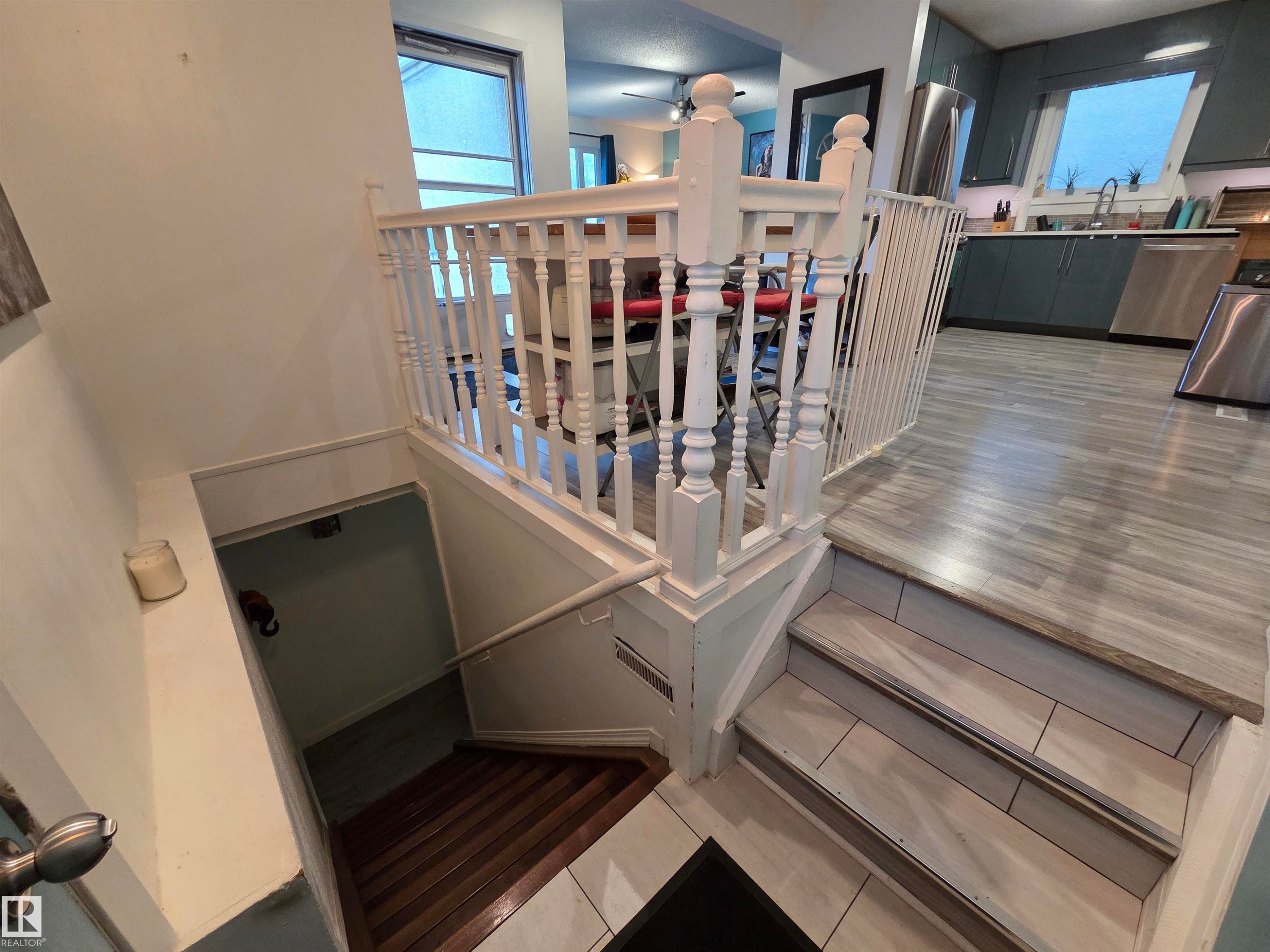 White painted baluster railing system with wood-finish flooring on the main level - 2514 149 Avenue, Edmonton, AB