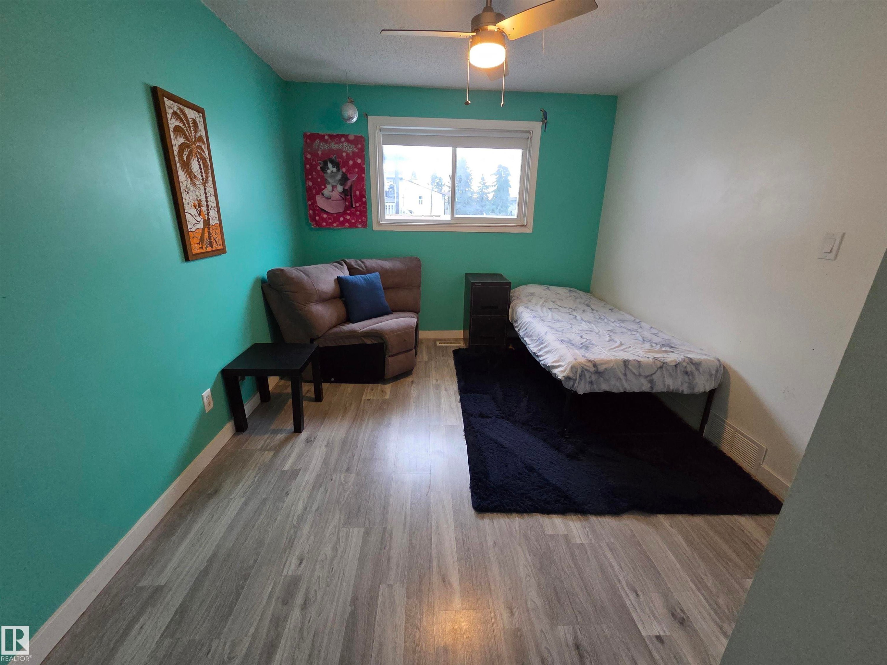 Room featuring wood-finish flooring and a ceiling fan with integrated lighting - 2514 149 Avenue, Edmonton, AB