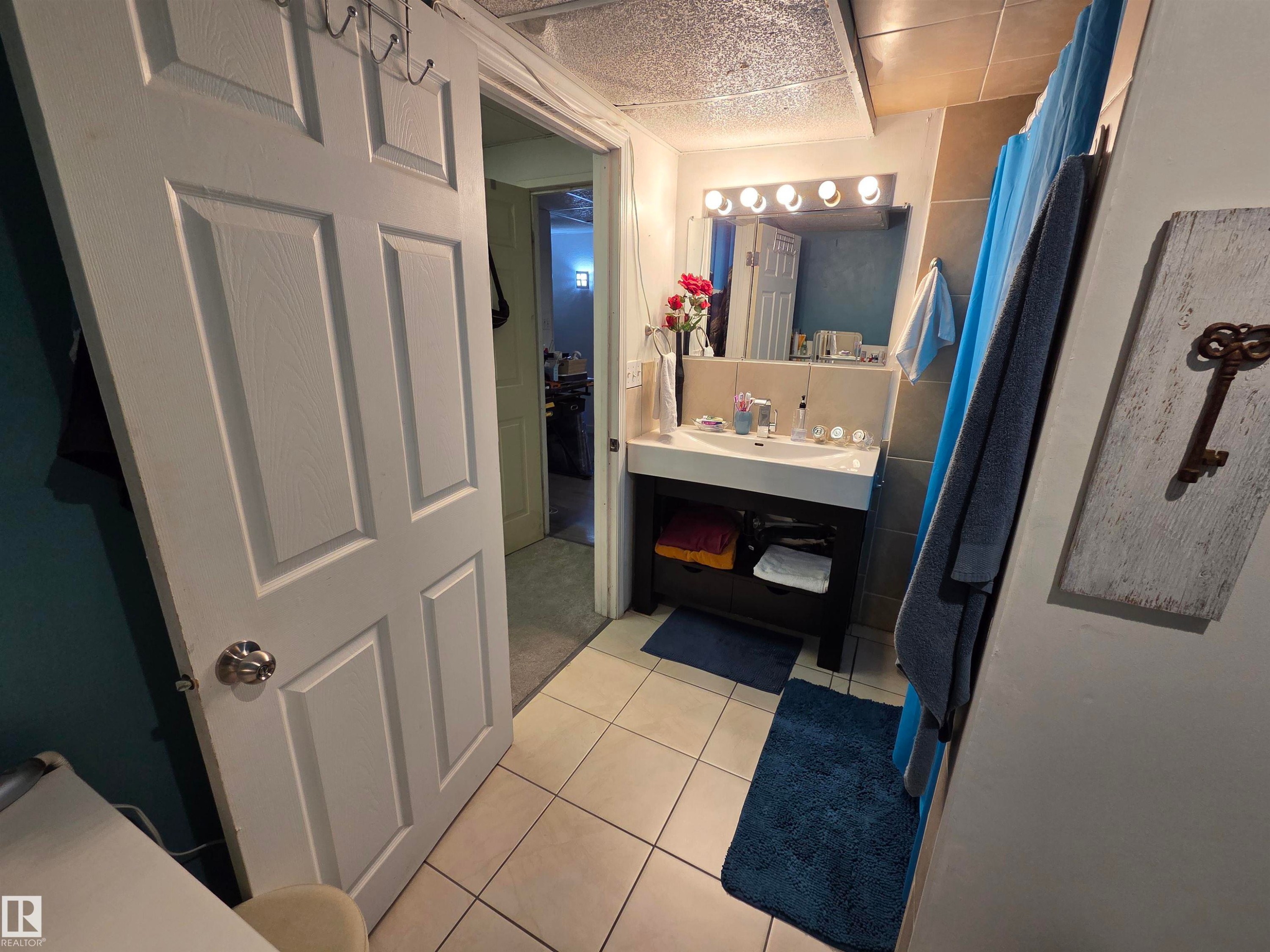 Bathroom featuring a rectangular vessel sink, dark wood-finish vanity, and overhead vanity lighting - 2514 149 Avenue, Edmonton, AB