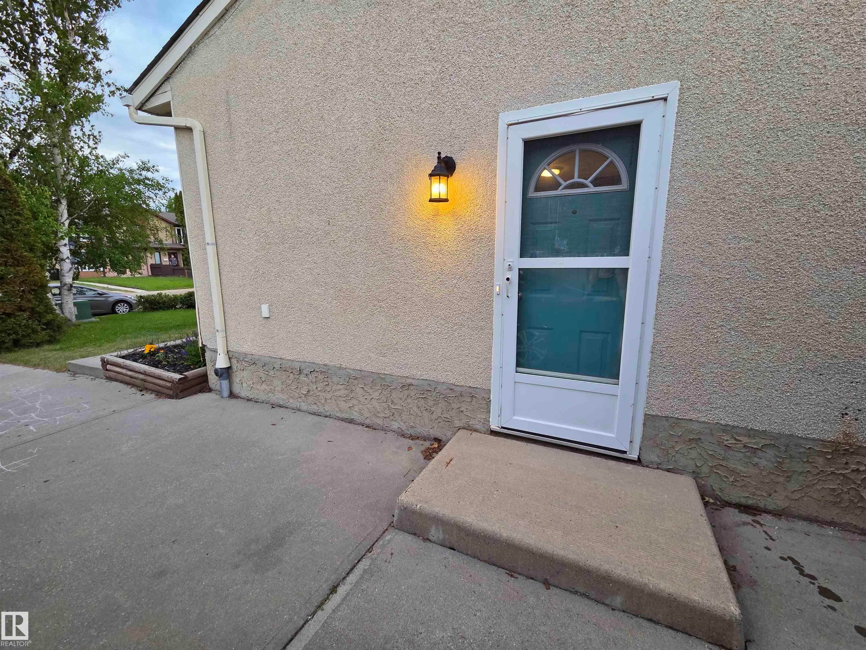 Textured exterior siding with a concrete walkway and entry step - 2514 149 Avenue, Edmonton, AB