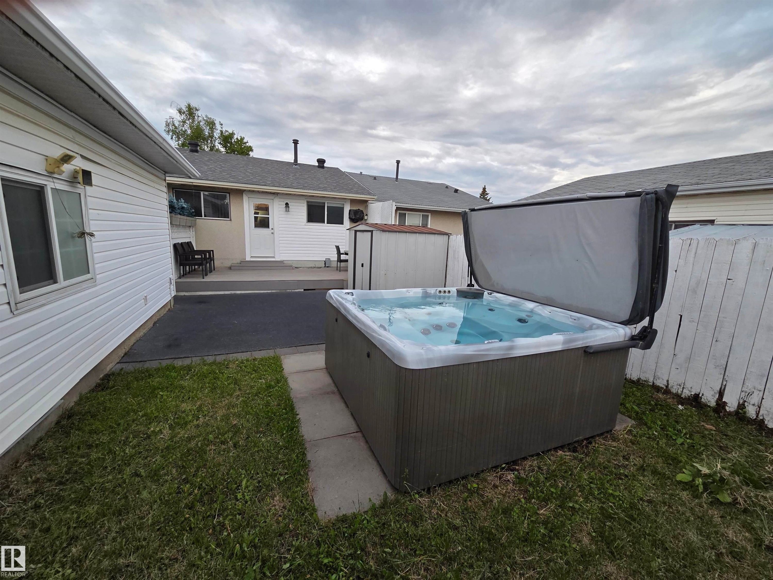 Outdoor spa with a grey exterior and open cover - 2514 149 Avenue, Edmonton, AB