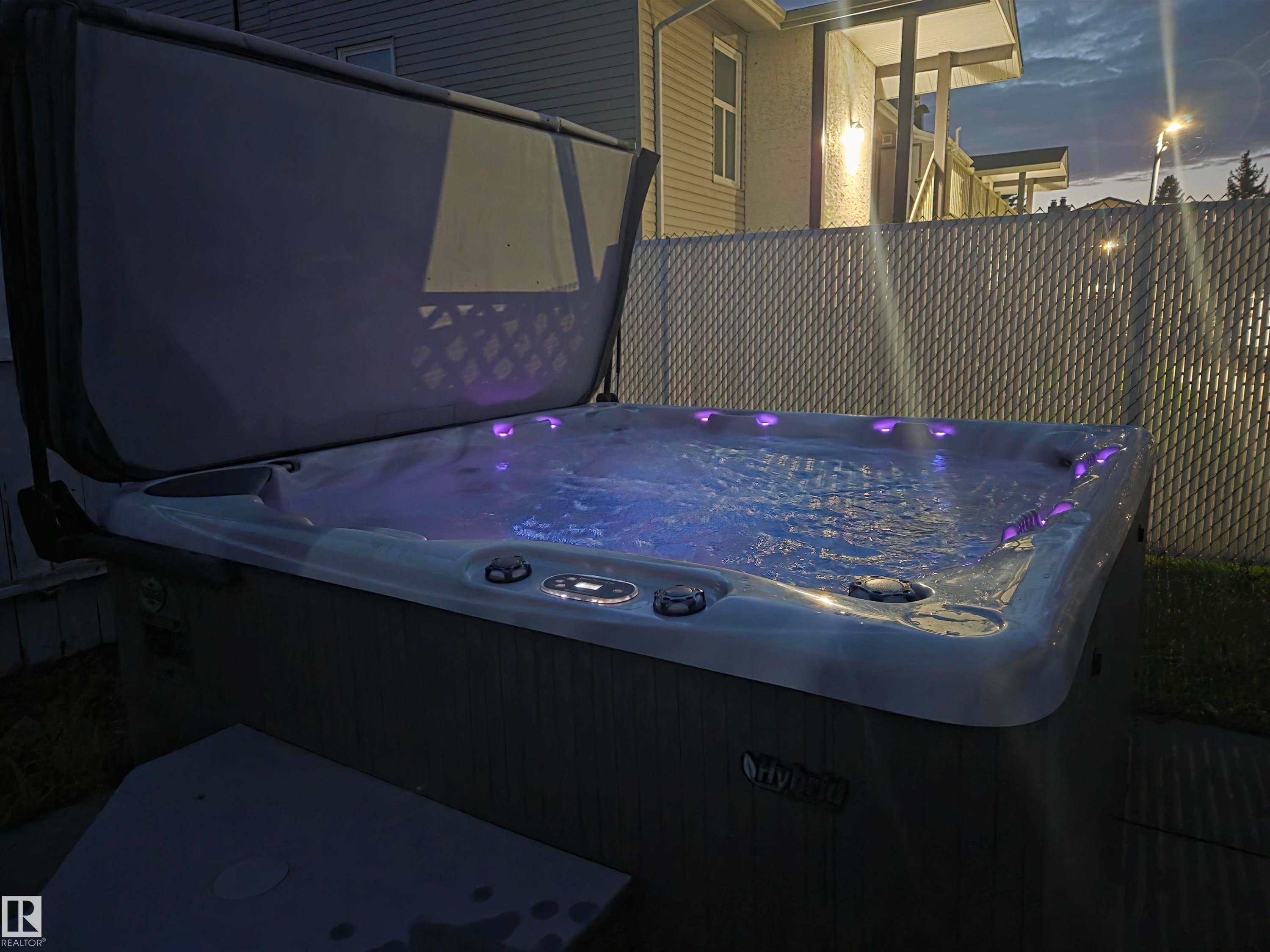 Outdoor spa with illuminated jets and a protective cover - 2514 149 Avenue, Edmonton, AB