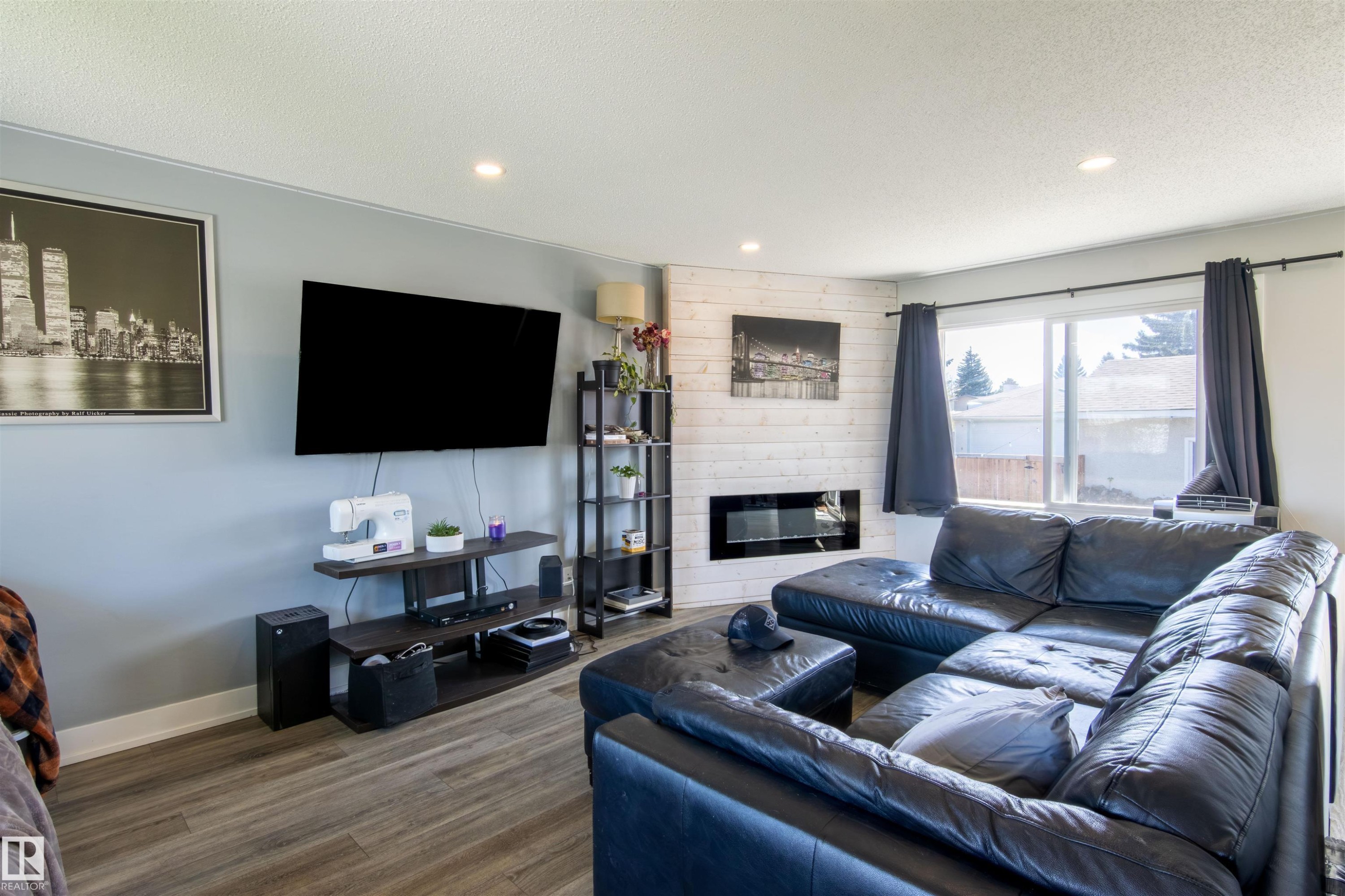 Living area with wood-finish flooring, recessed lighting, and a prominent window - 7115 39A Avenue, Edmonton, AB - Indoor Photo Showing Living Room With Fireplace
