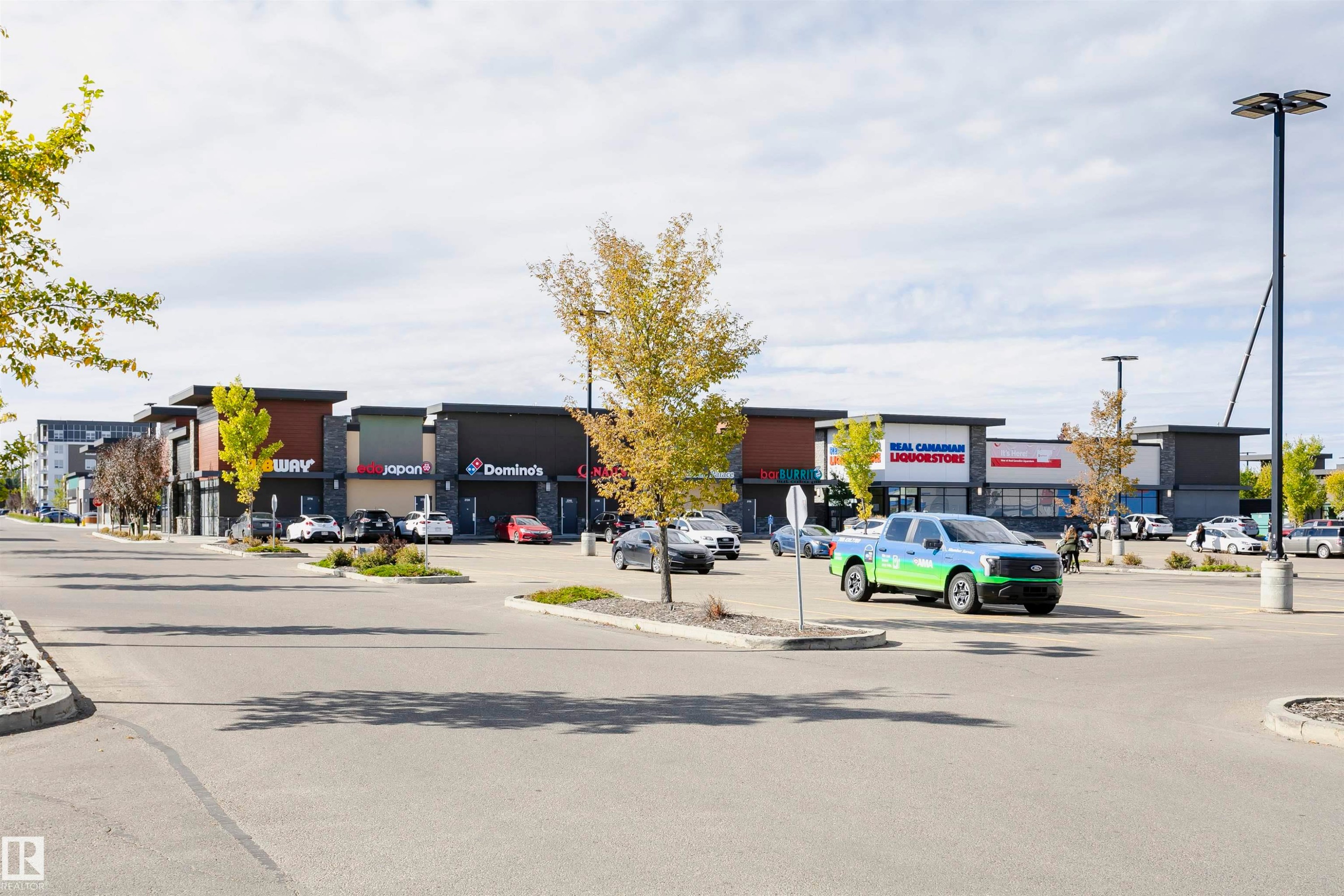 Modern commercial complex featuring diverse retail storefronts - 404 12045 22 Avenue, Edmonton, AB