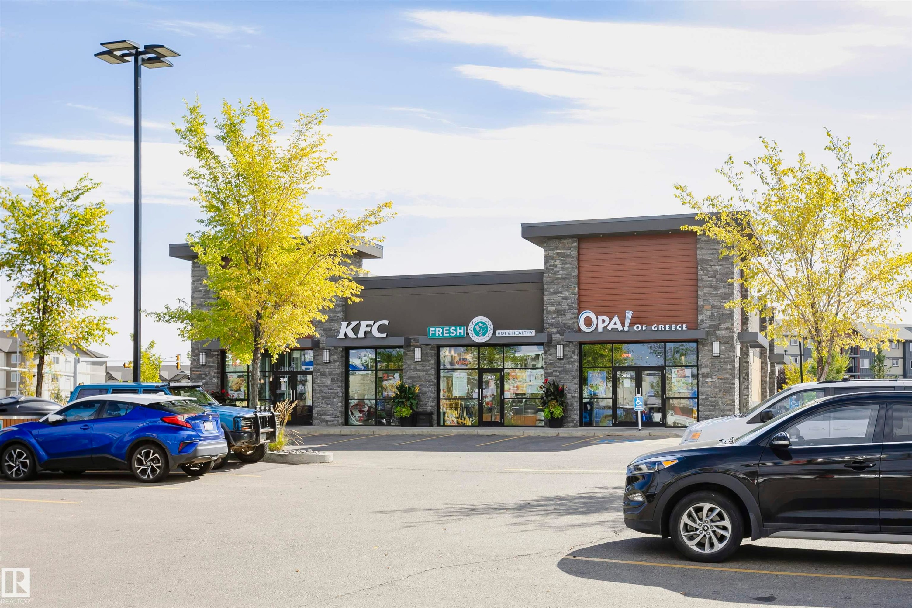 Modern commercial building with stone facade accents and wood-finish paneling - 404 12045 22 Avenue, Edmonton, AB