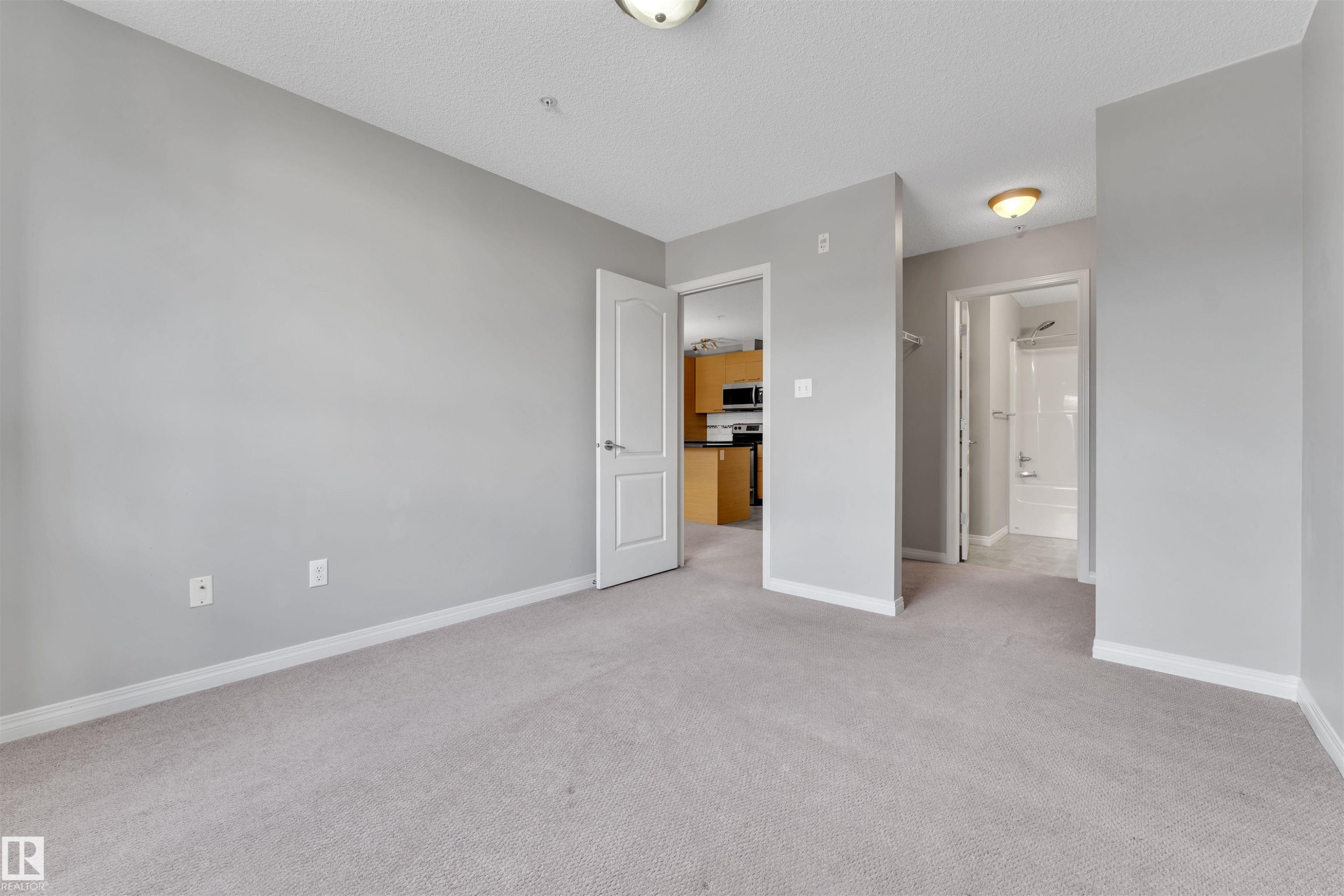 Carpeted room with light gray wall paint and white trim, featuring a flush mount ceiling light - #3302 9351 Simpson Dr Nw, Edmonton, AB