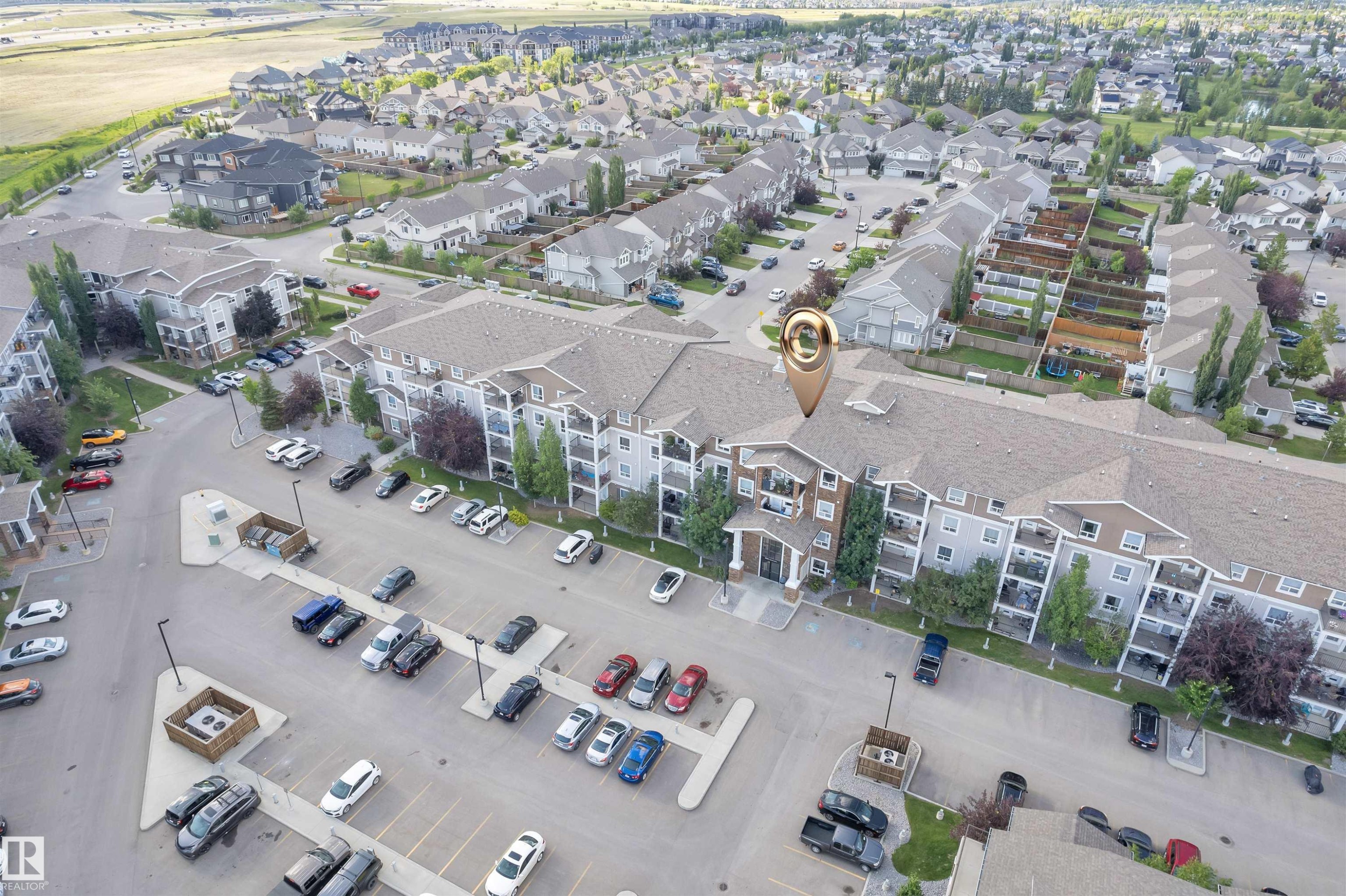 Multi-level residential building featuring exterior balconies, a dedicated parking area, and mature landscaping - #3302 9351 Simpson Dr Nw, Edmonton, AB