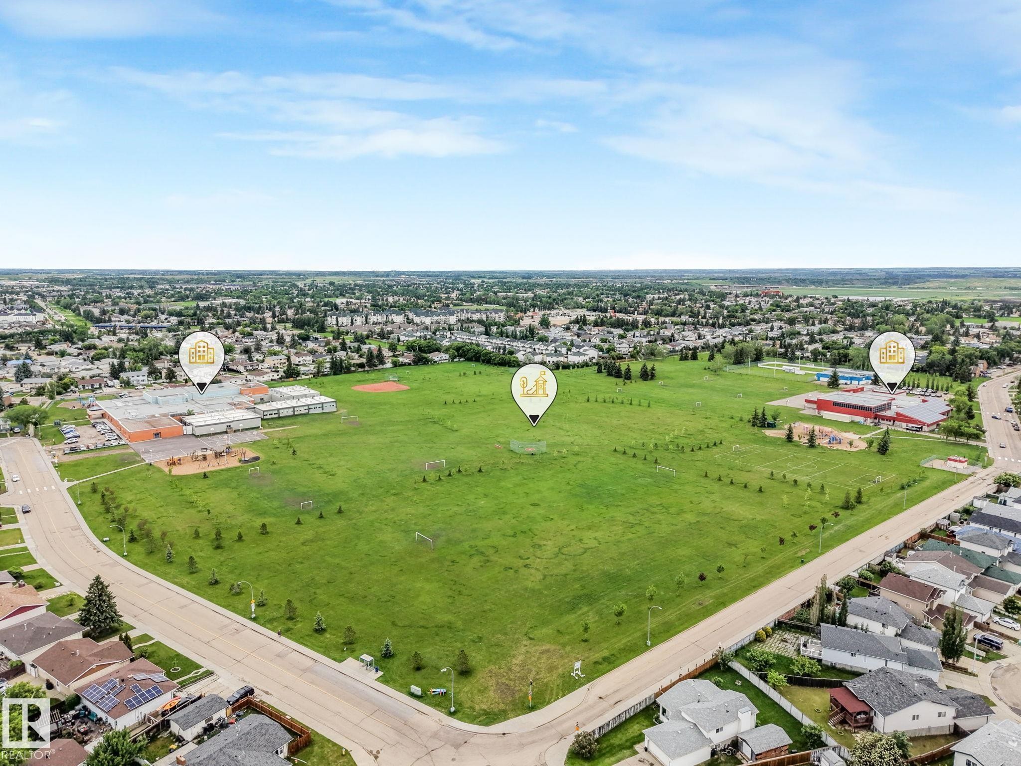Aerial view of nearby Overlanders School and park featuring a baseball pitch, soccer field and jungle gym. Also nearby is the Edmonton East Soccer Dome. - 2921 130 Avenue, Edmonton, AB