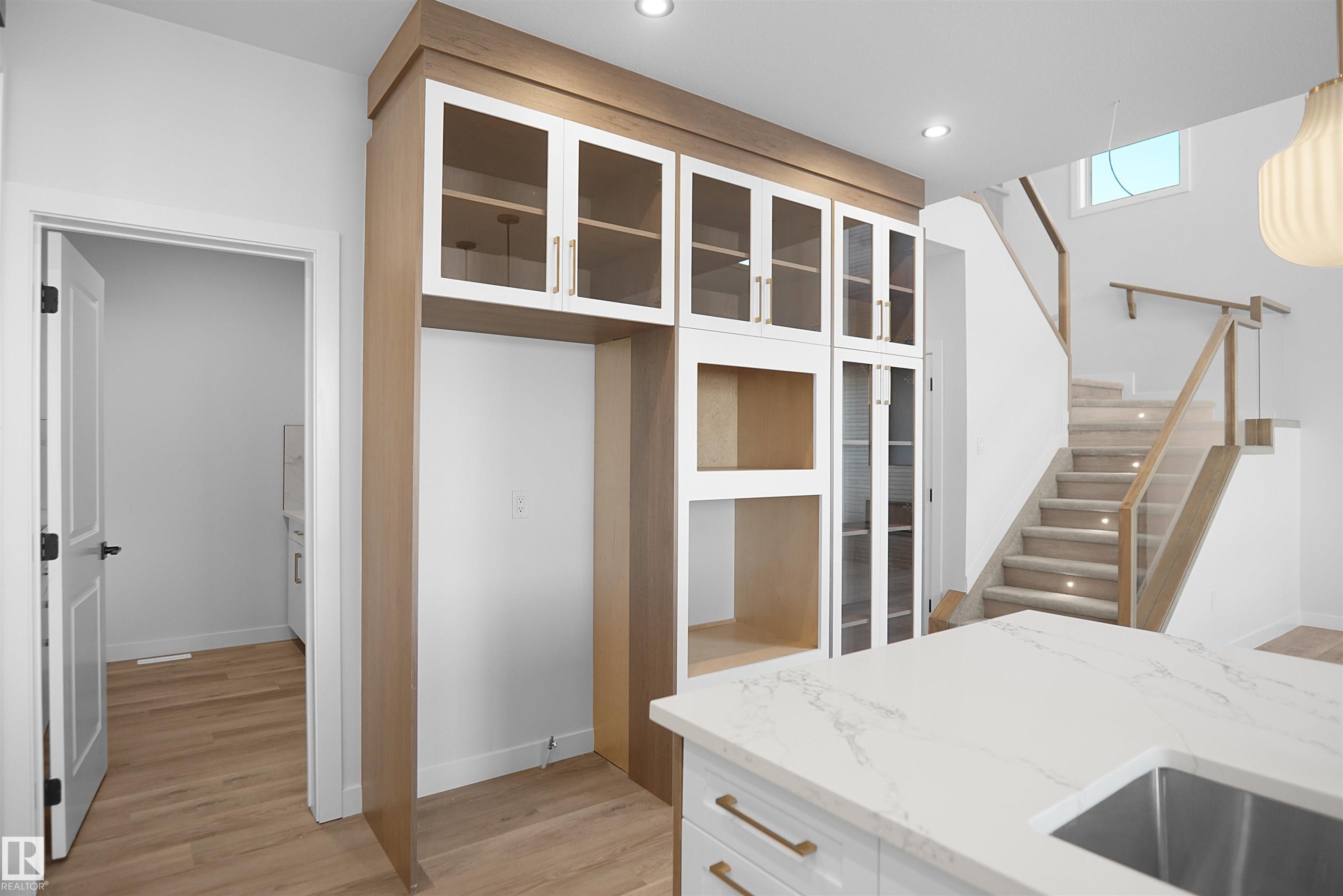 Integrated custom cabinetry featuring wood-finish framing and glass-front upper cabinets - 6403 29 Ave, Edmonton, AB - Indoor