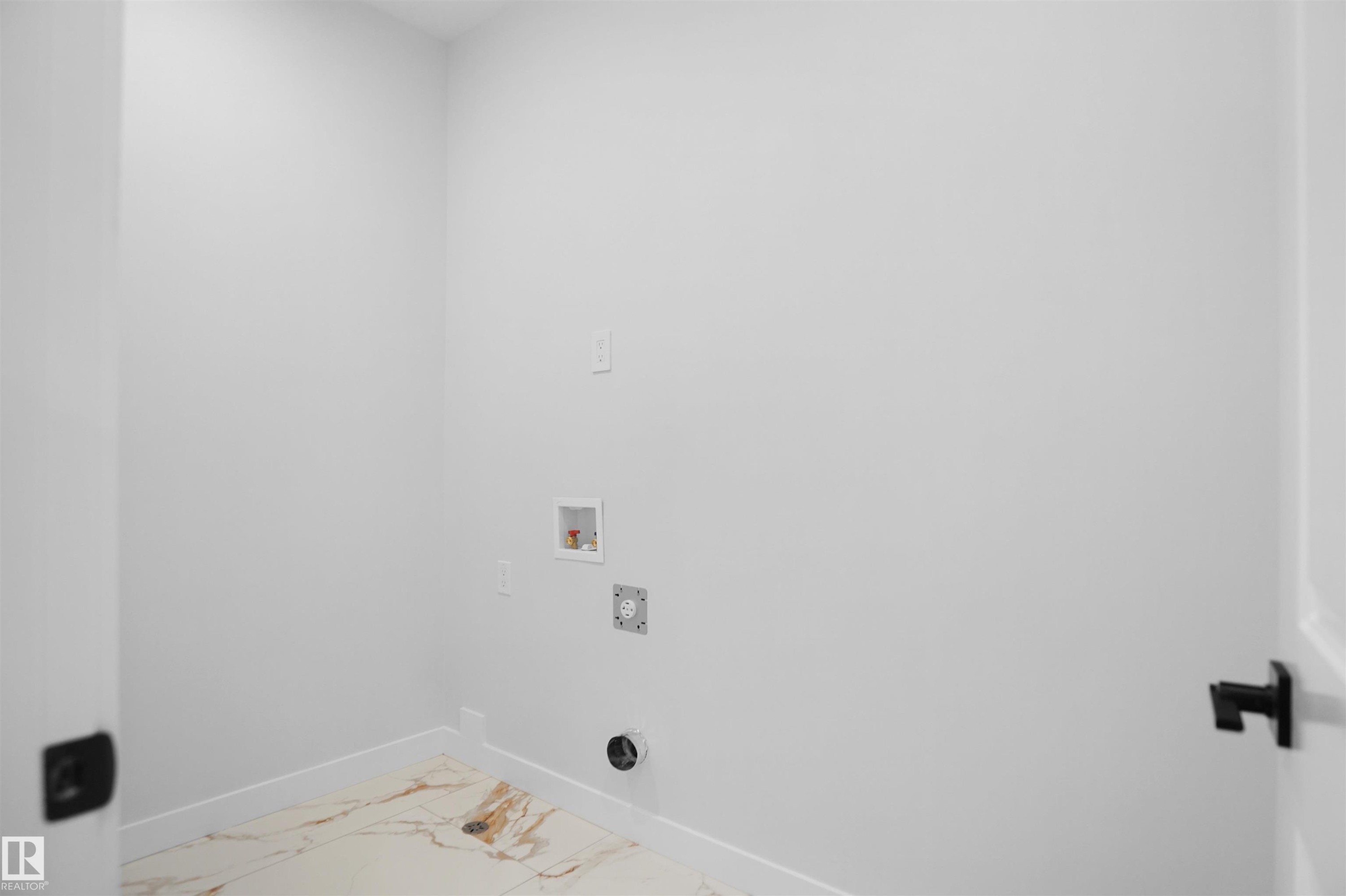 Dedicated laundry area featuring a tile floor with natural stone-look veining, white baseboards, and light-toned walls - 6403 29 Ave, Edmonton, AB - Indoor Photo Showing Other Room