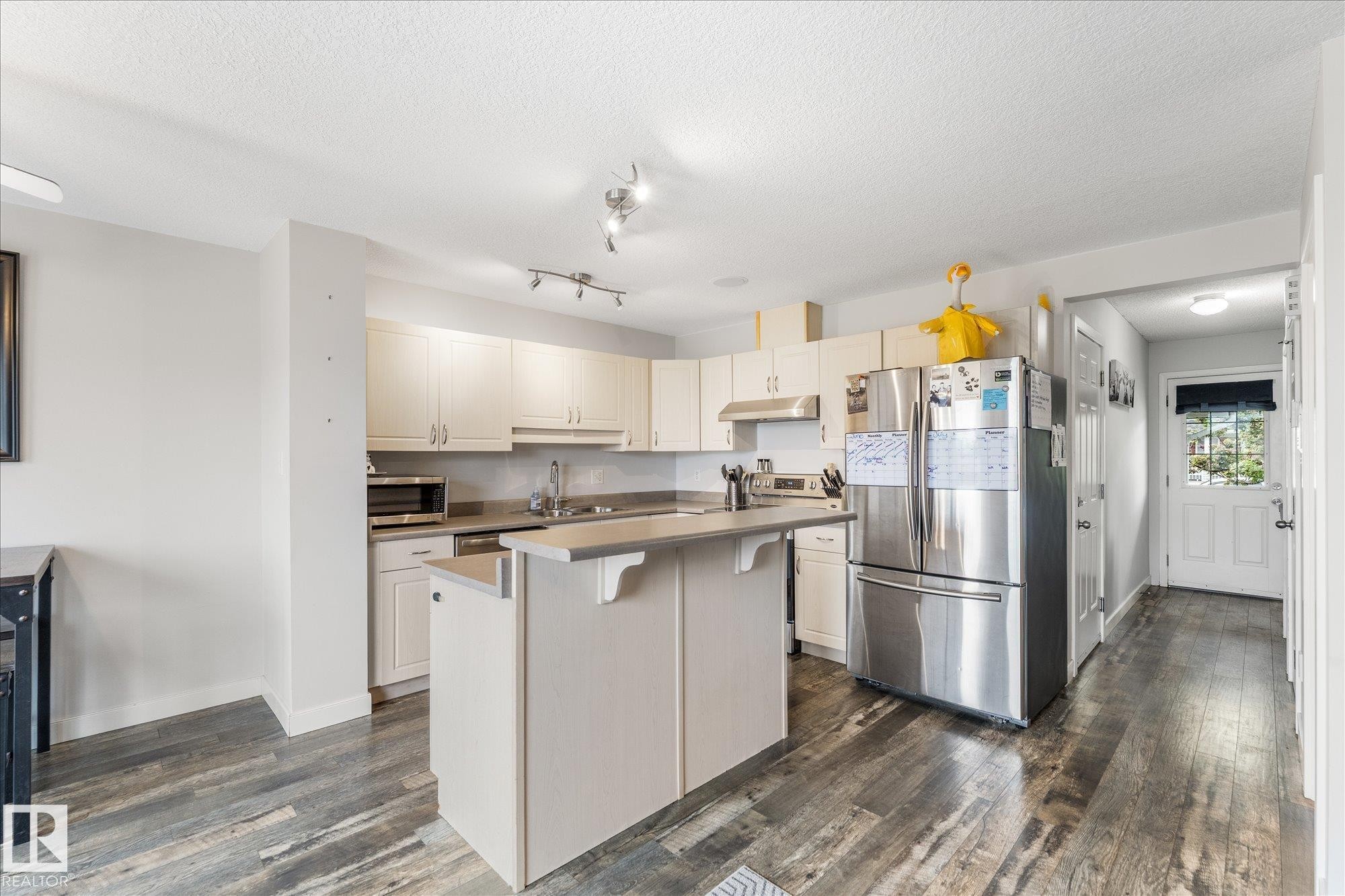 Contemporary kitchen featuring light wood-finish cabinetry and stainless steel appliances - 2324 30 Avenue, Edmonton, AB