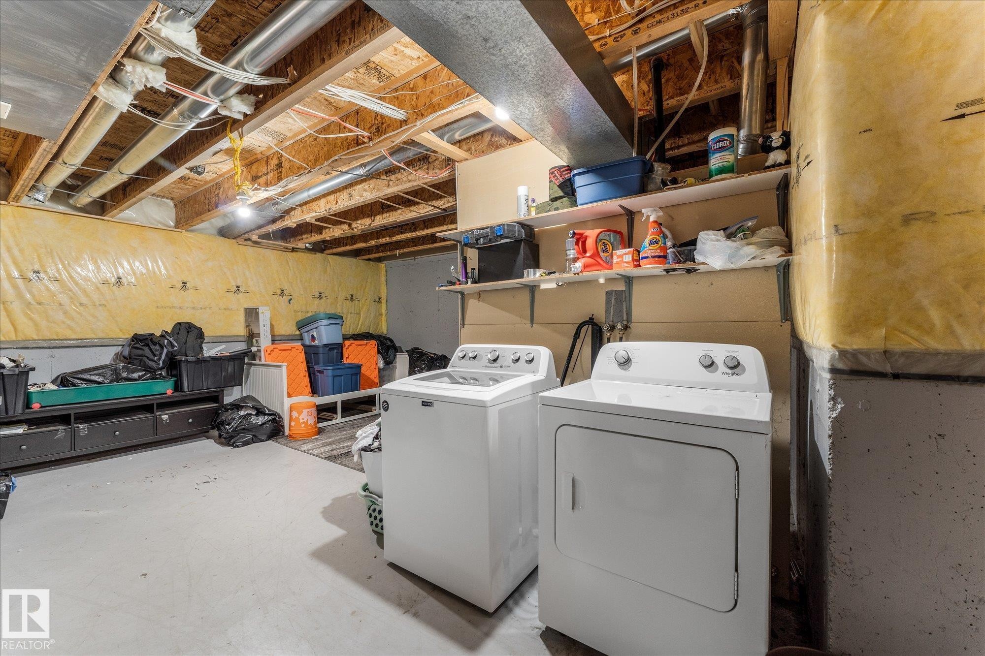 Utility space featuring exposed ceiling joists and ductwork, a concrete floor, and installed wall shelving - 2324 30 Avenue, Edmonton, AB