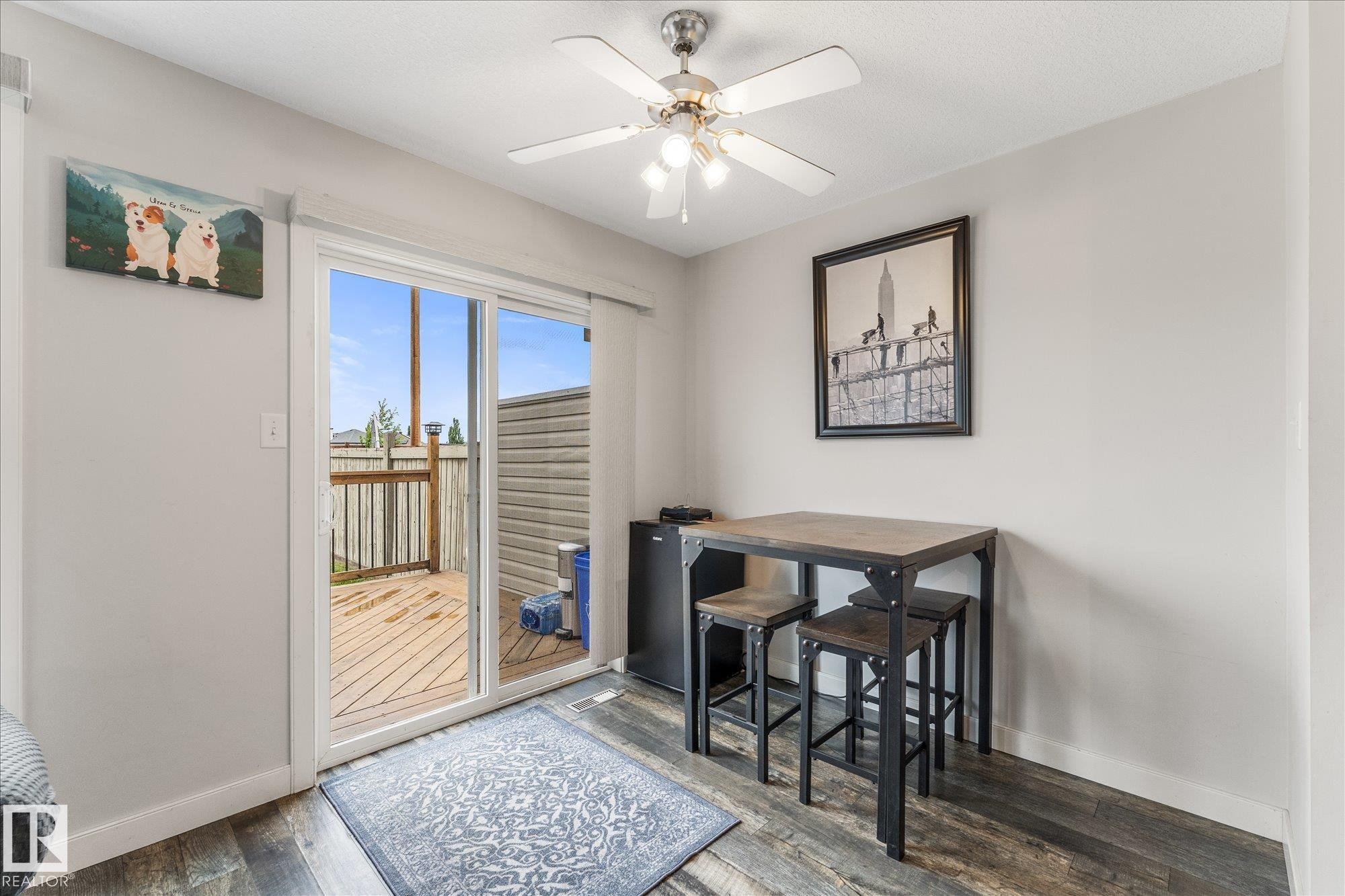 Dining area featuring wood-finish flooring, a ceiling fan, and light gray wall paint - 2324 30 Avenue, Edmonton, AB