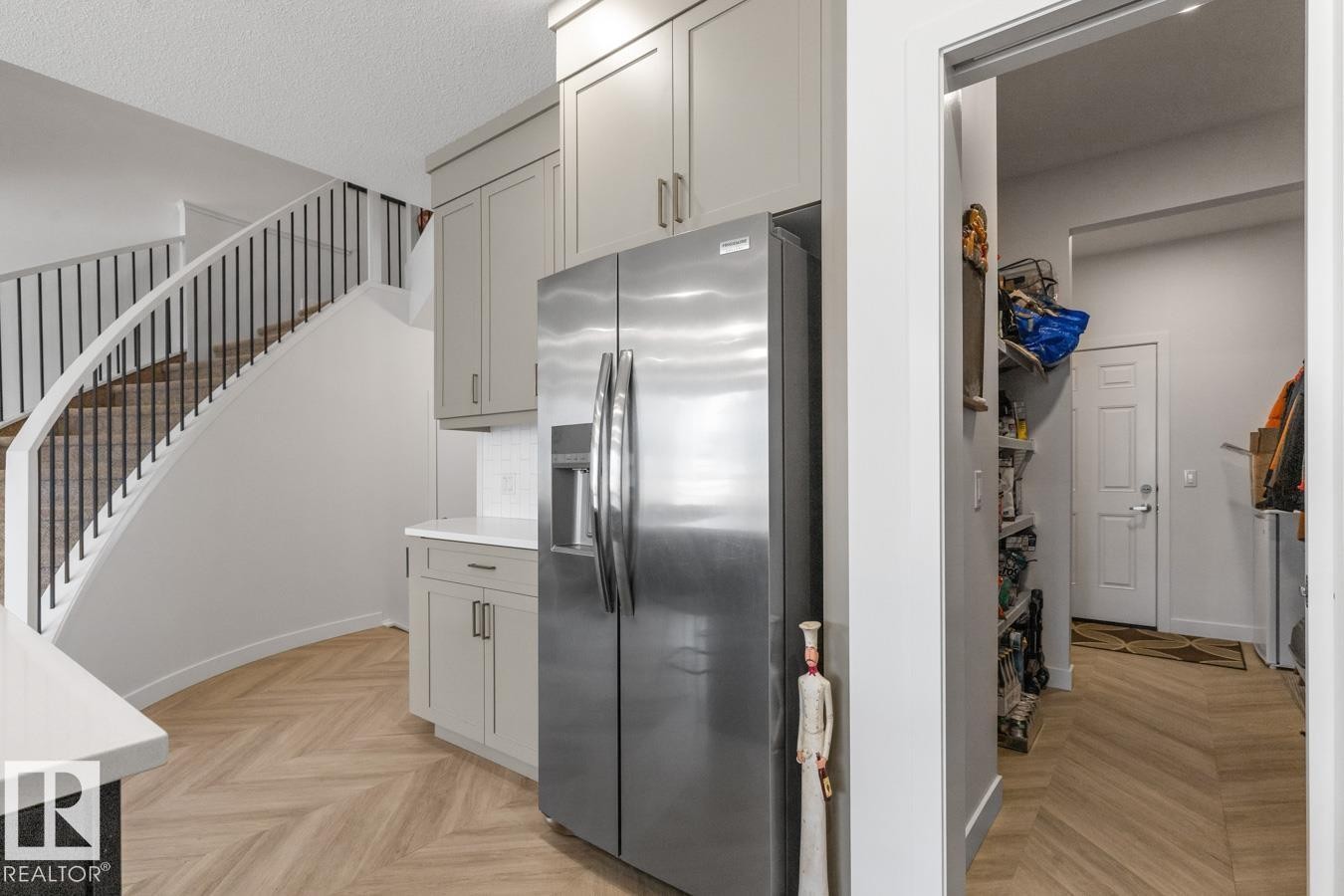 Kitchenette featuring light gray cabinetry with brushed nickel hardware, a stainless steel refrigerator, white countertops, and a white subway tile backsplash - 117 Paisley Gate Gate, Edmonton, AB