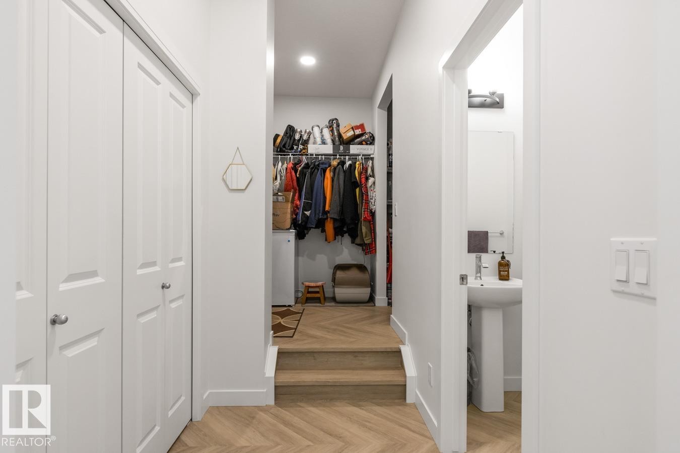 Hallway featuring wood-finish flooring with a herringbone pattern, white walls, and recessed lighting - 117 Paisley Gate Gate, Edmonton, AB