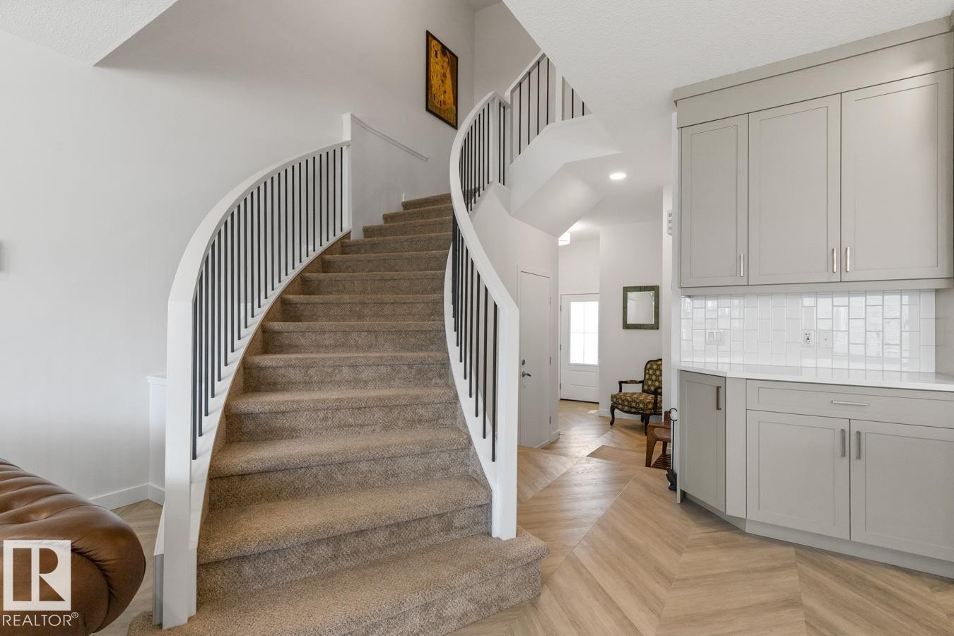 Curved staircase with carpeted treads and white banister featuring black vertical balusters - 117 Paisley Gate Gate, Edmonton, AB