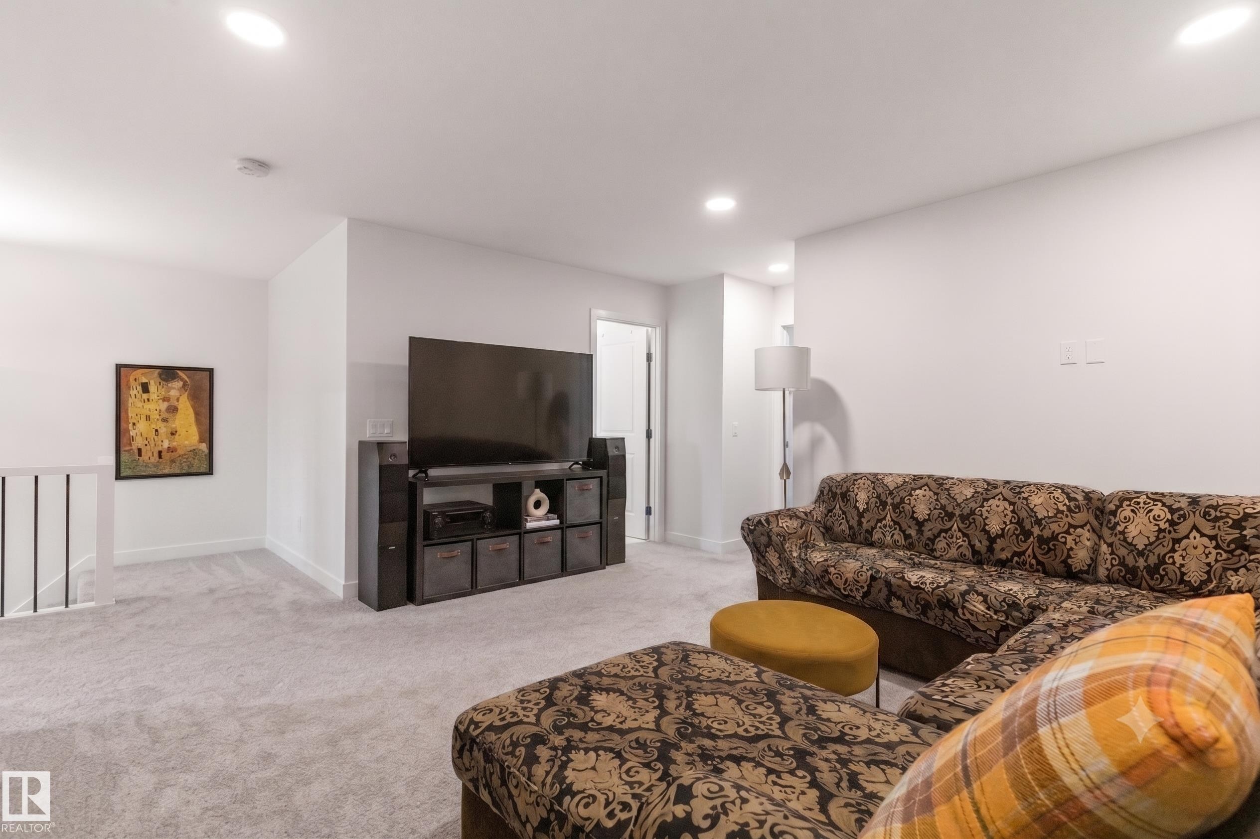 Carpeted living area featuring recessed ceiling lighting, a white painted wall finish, and white baseboards - 117 Paisley Gate Gate, Edmonton, AB