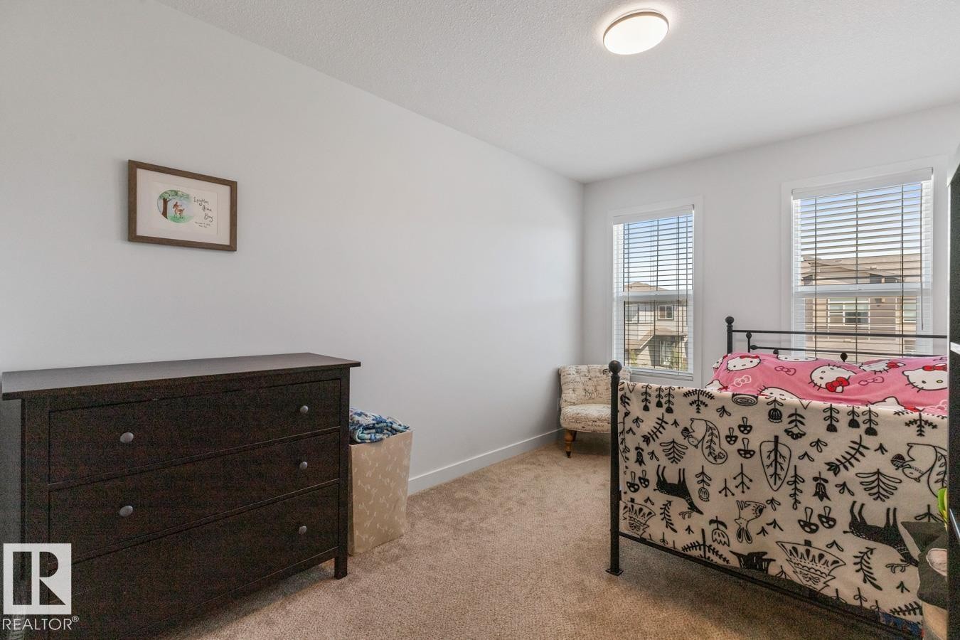 Bright room featuring two windows with blinds, neutral carpeting, and white walls - 117 Paisley Gate Gate, Edmonton, AB