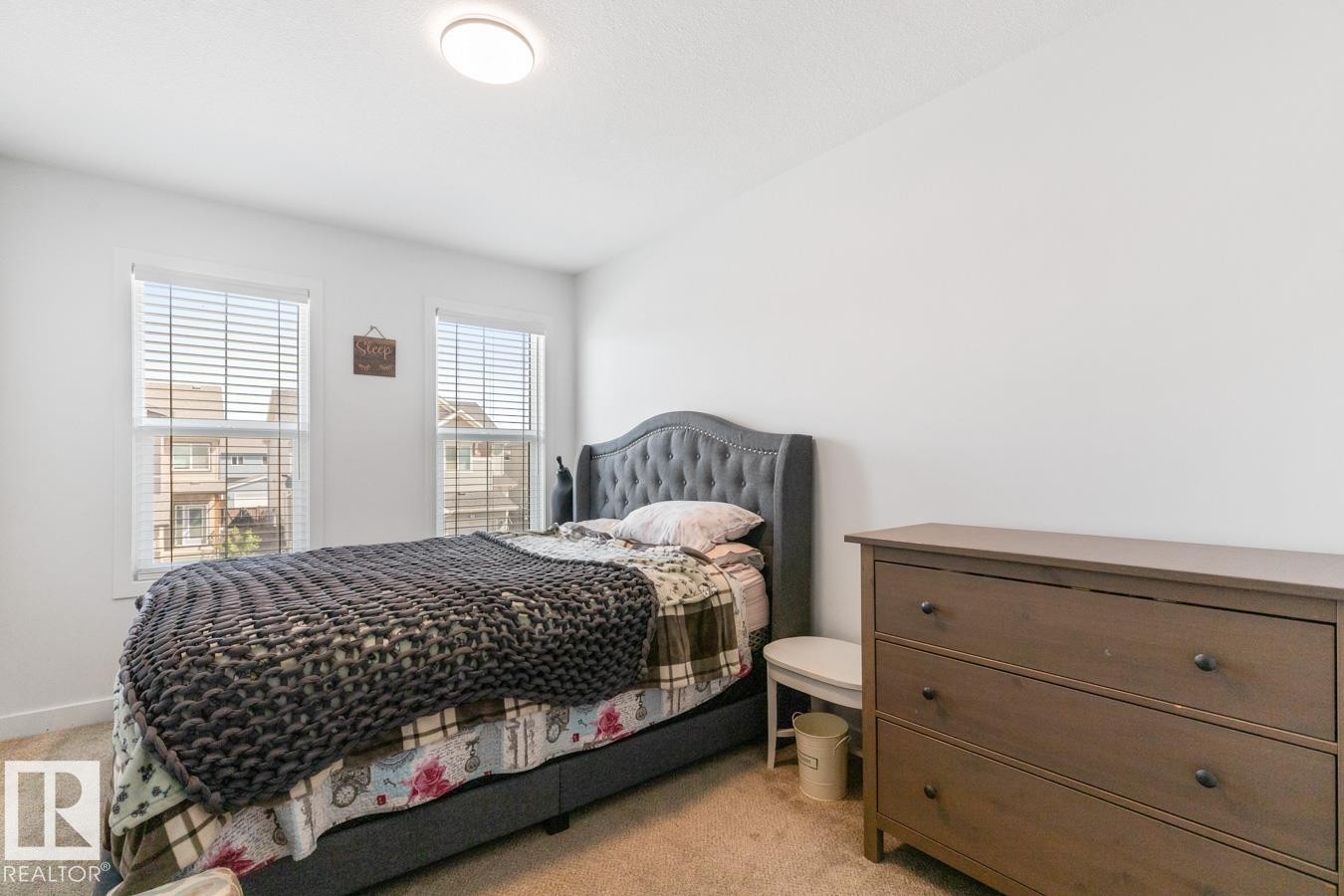 Room featuring two windows with blinds, light-colored walls, and neutral carpet flooring - 117 Paisley Gate Gate, Edmonton, AB