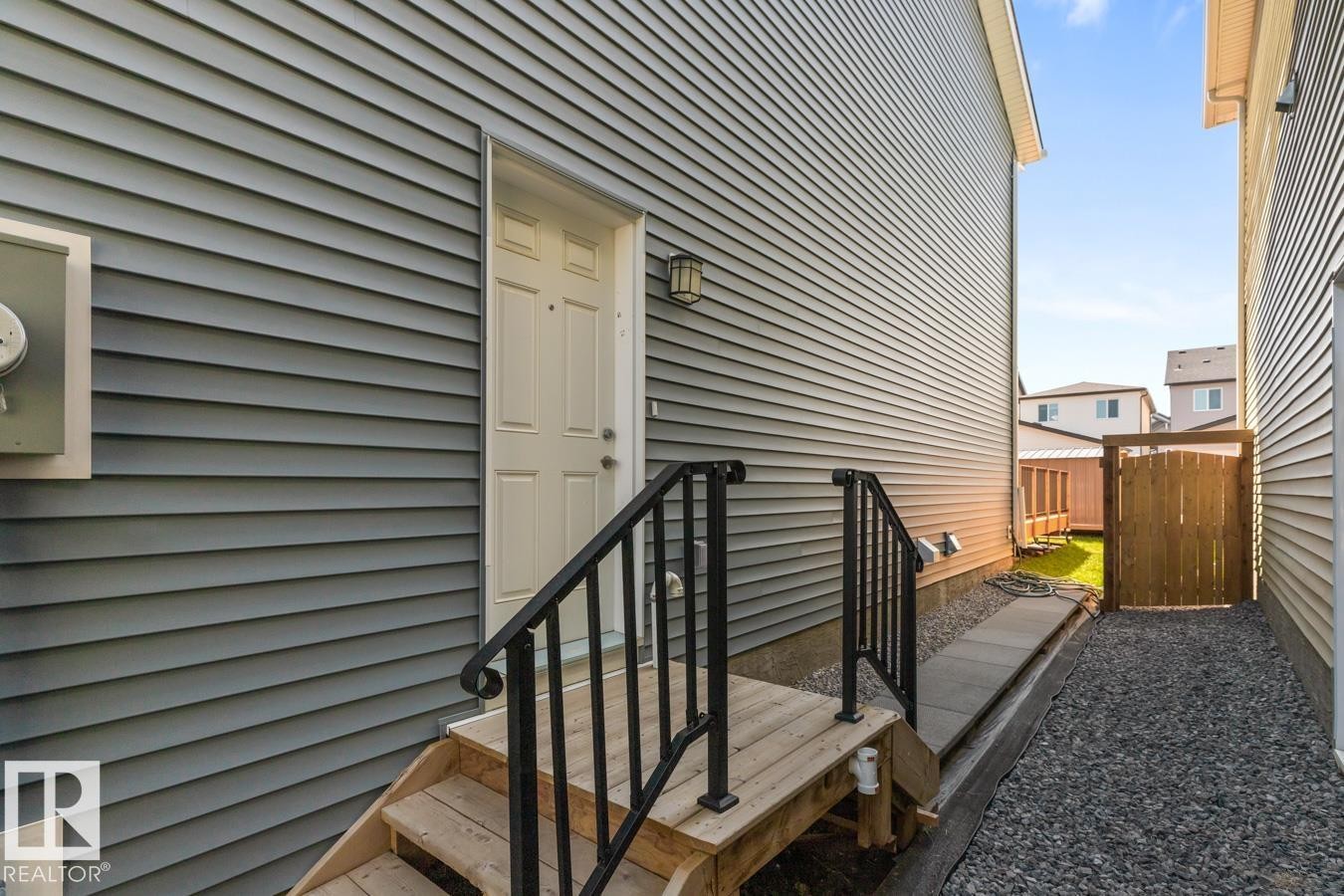 Side entrance with wooden steps and black metal railings - 117 Paisley Gate Gate, Edmonton, AB